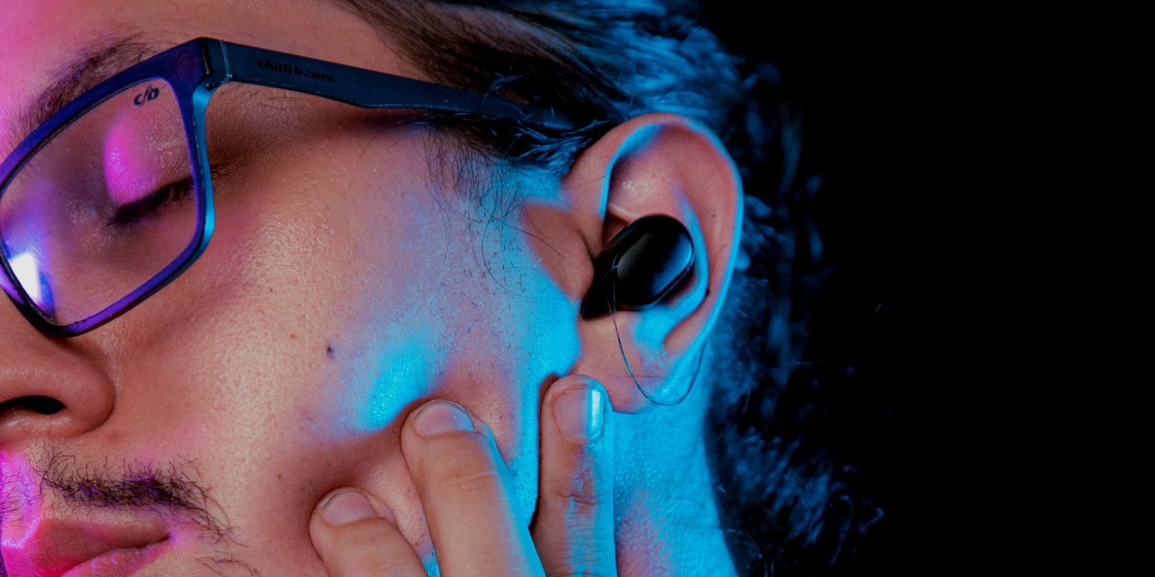 Man wearing glasses sleeping with earbuds on