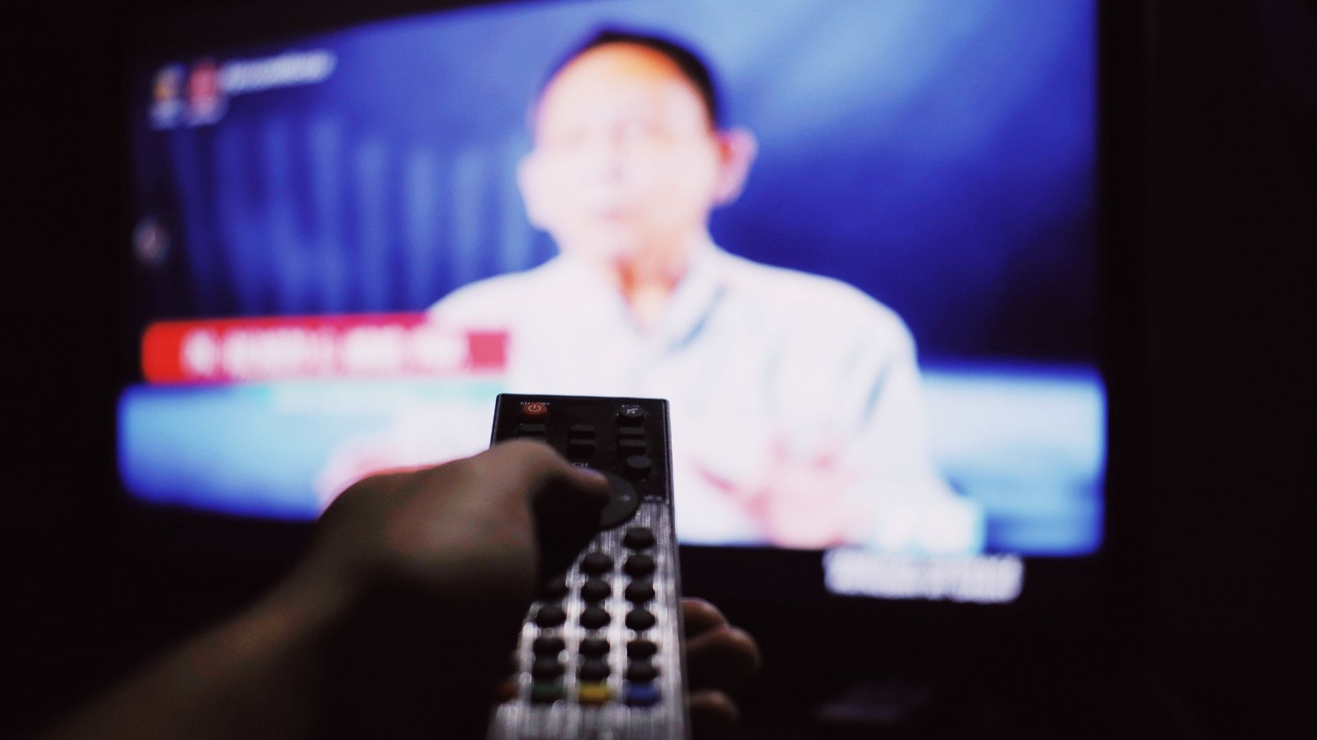 person pointing a remote at a tv