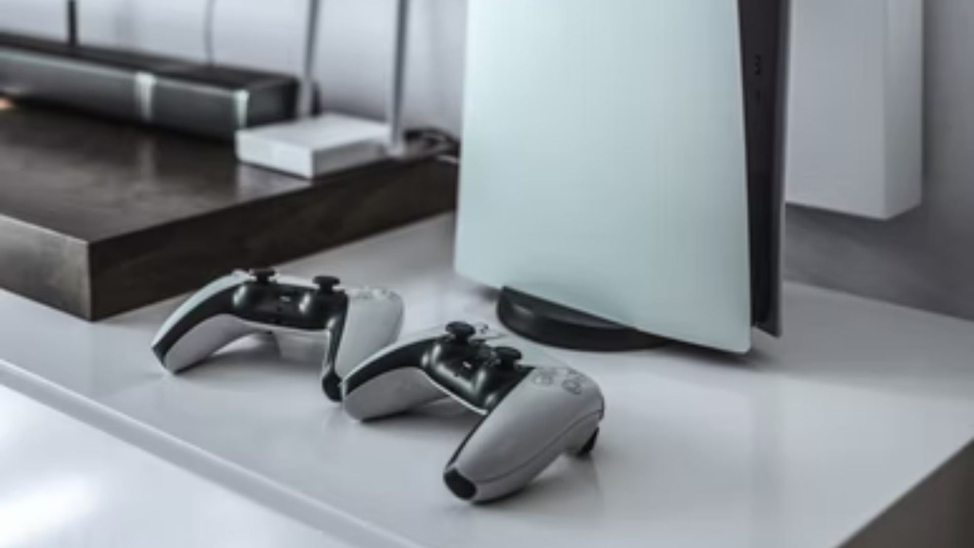 playstation 5 console on an entertainment center, with two dualsense controllers in front of it