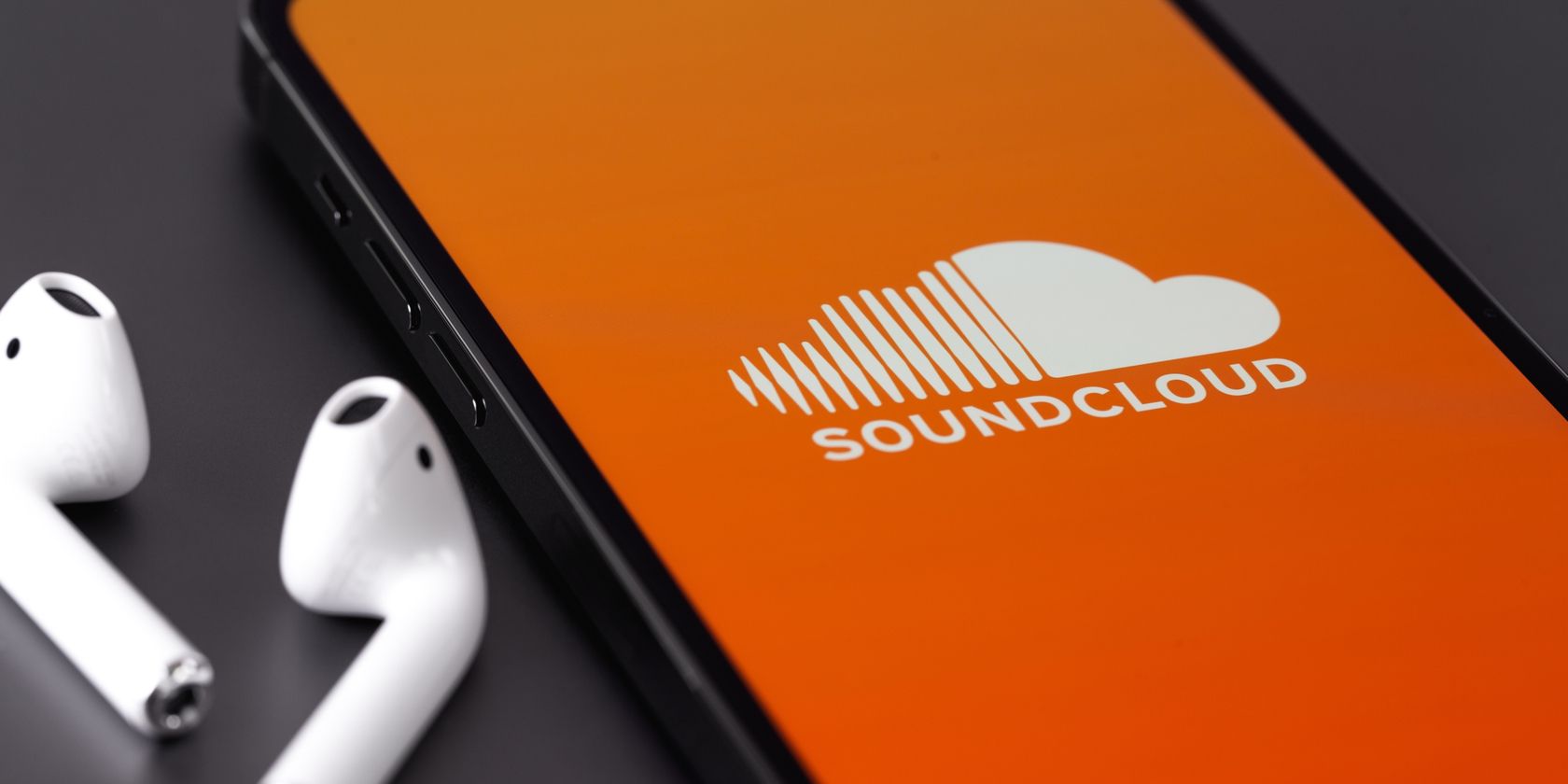 Soundcloud-логотип-на-телефоне-рядом-в-наушниках