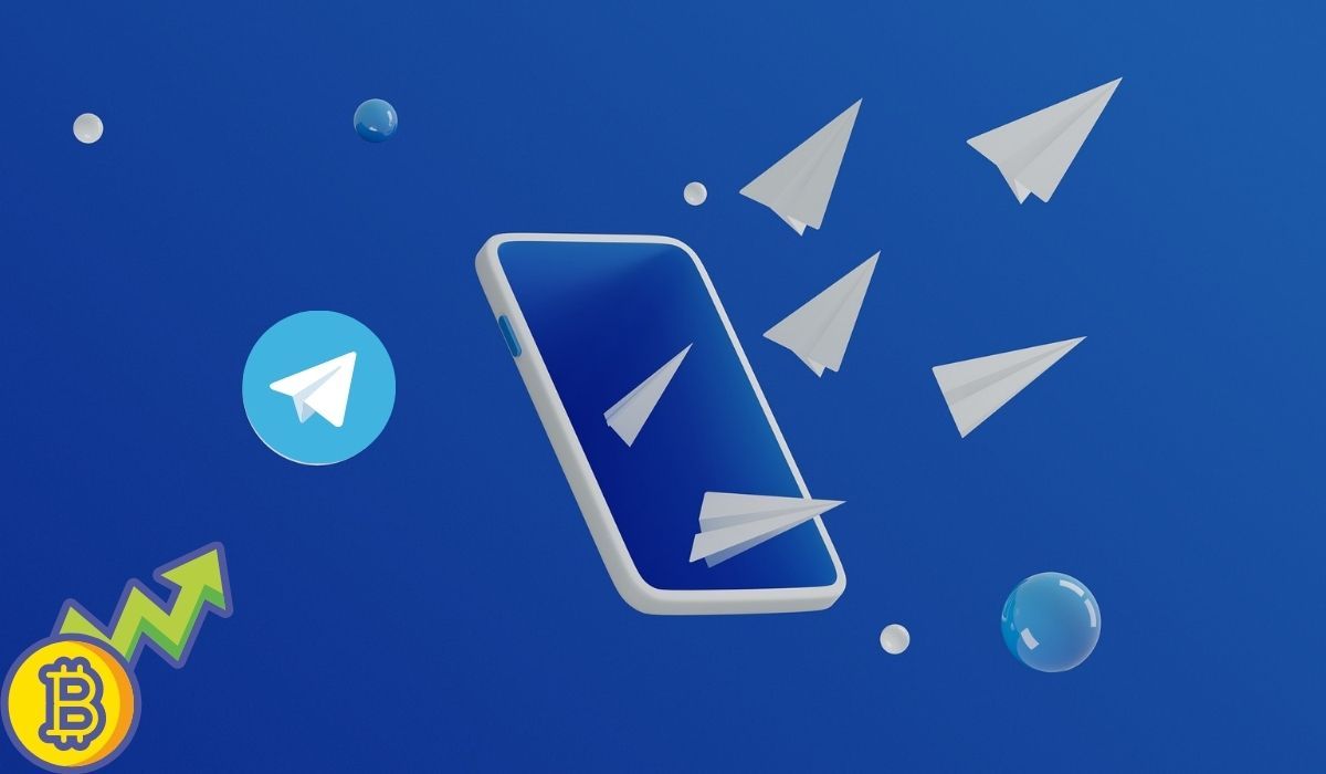 Telegram and bitcoin logos are seen on a blue background next to a smartphone