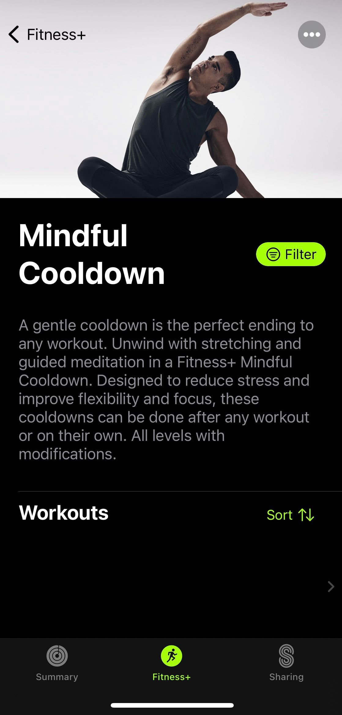 Screenshot from Apple Fitness+ app showing a person stretching with an explanation of mindful cooldowns 