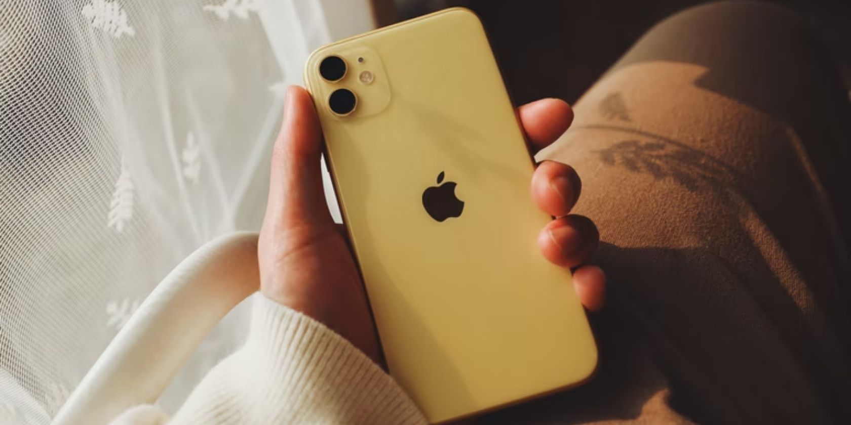 hand holding yellow iphone