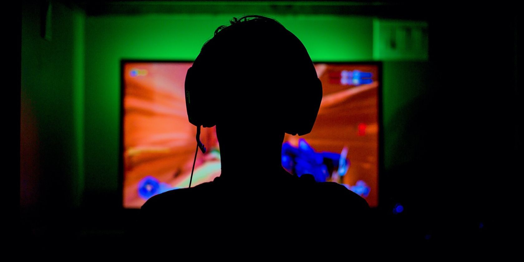 Man with headphones on playing a video game