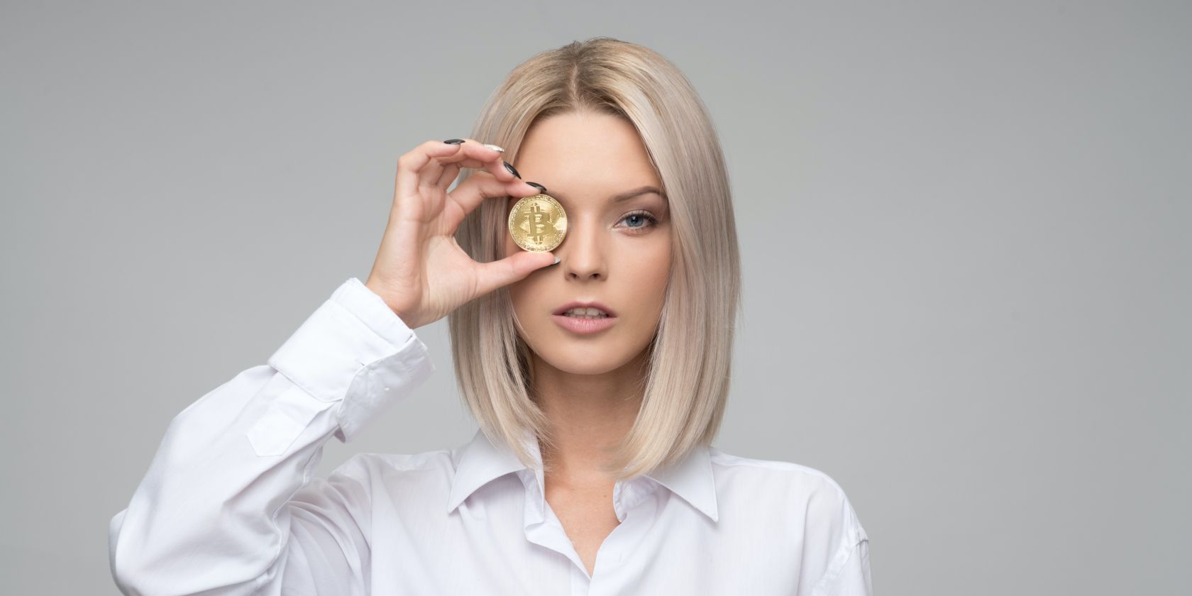 Woman Holding a Bitcoin Up to Her Eye