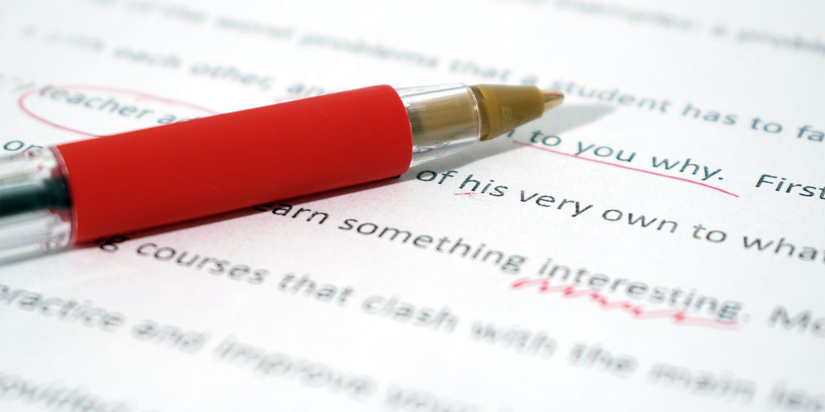 a red pen on a document being grammatically corrected