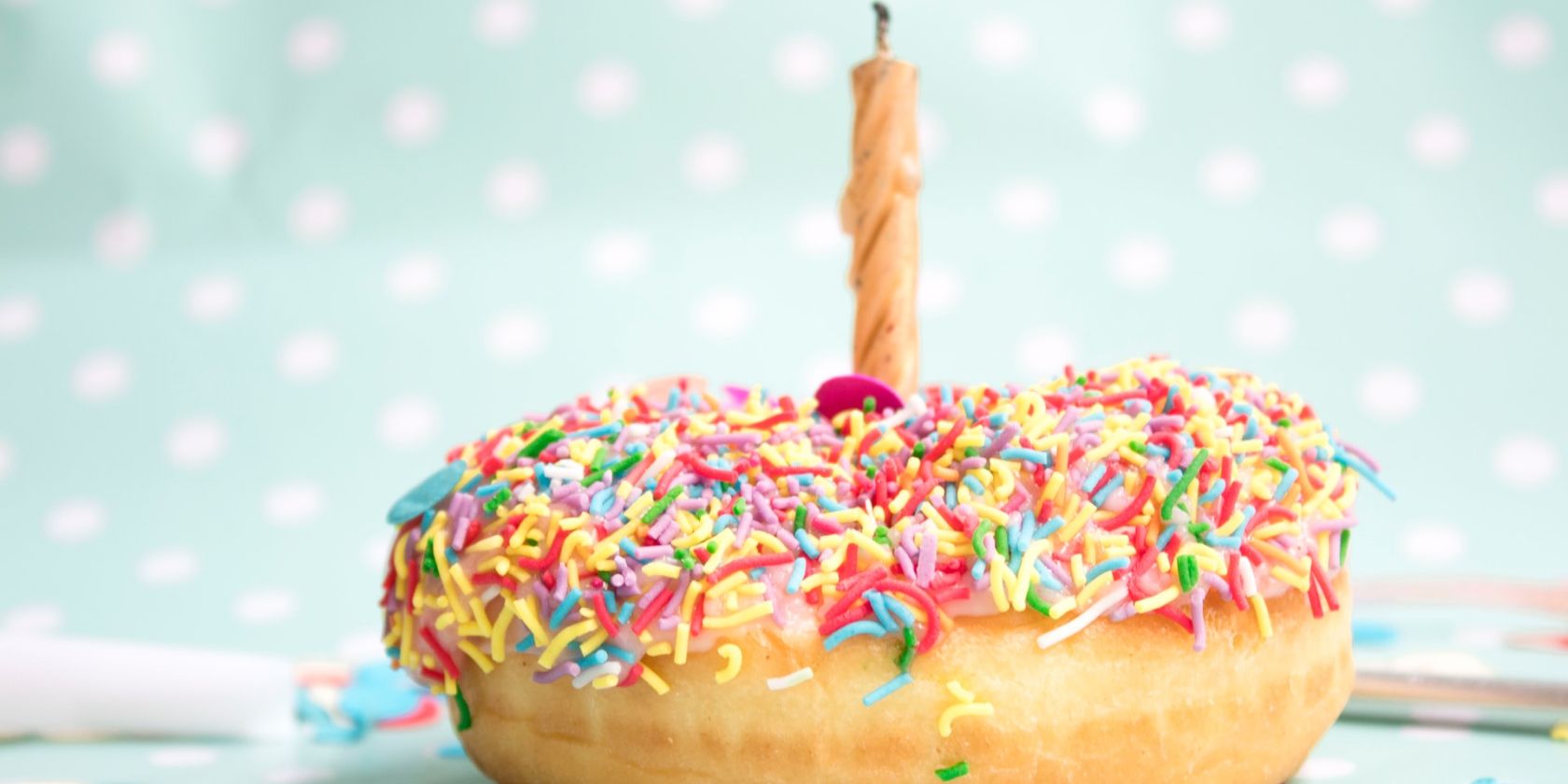 a doughnut topped with sprinkles and a candle