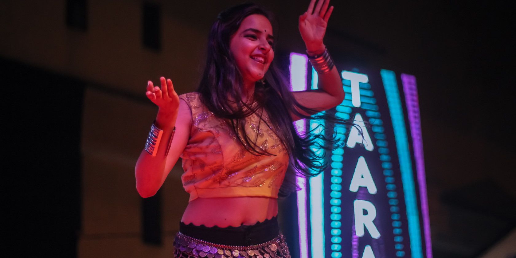 Woman smiling and performing Bollywood dance routine