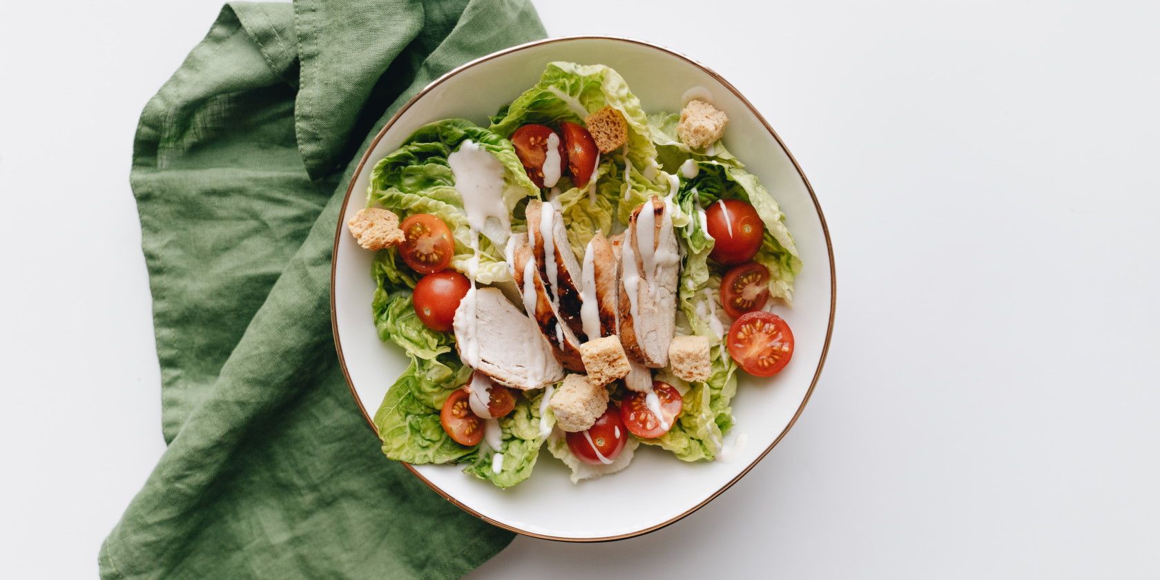 close-up of chicken tomato lettuce salad in bowl on white table