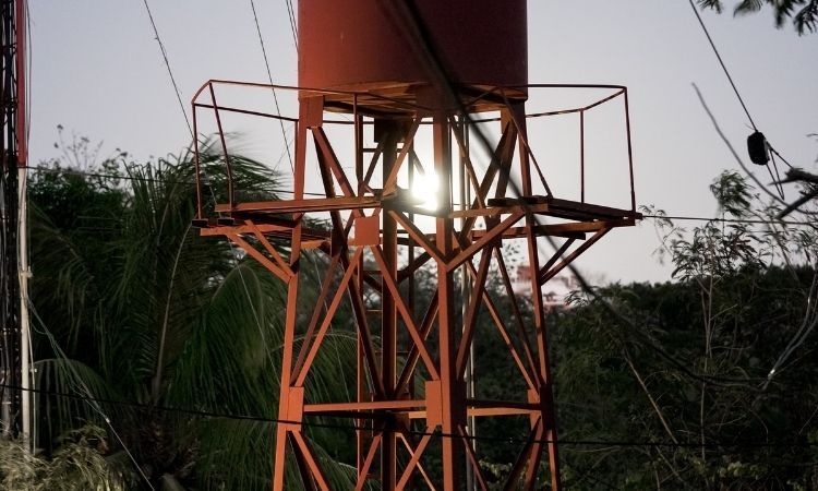 brown copper-colored water tower in tropical forest