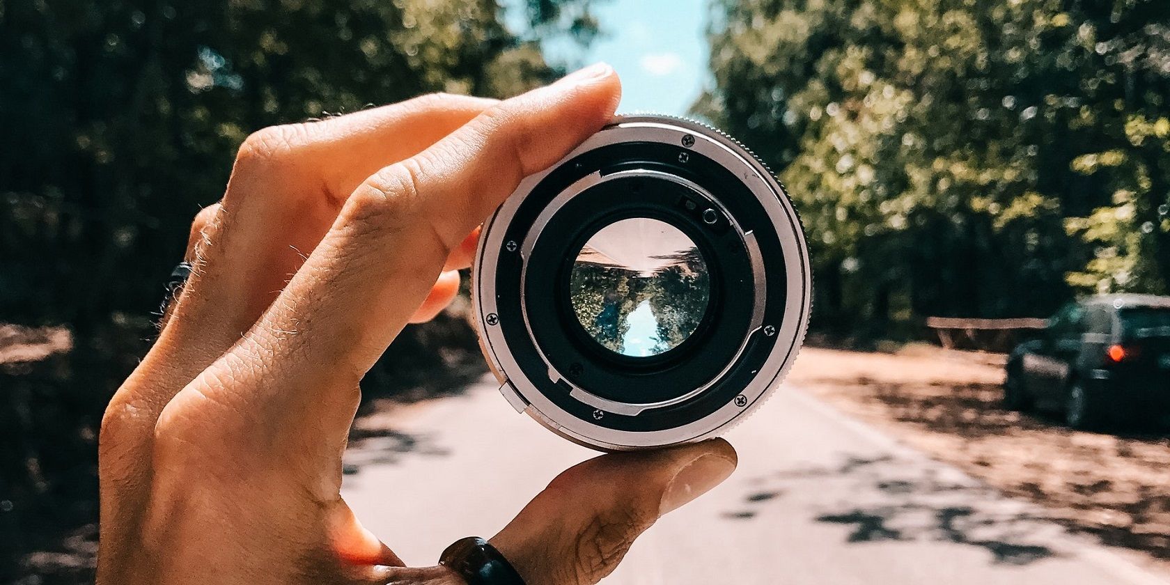 photo of a person holding a camera lens