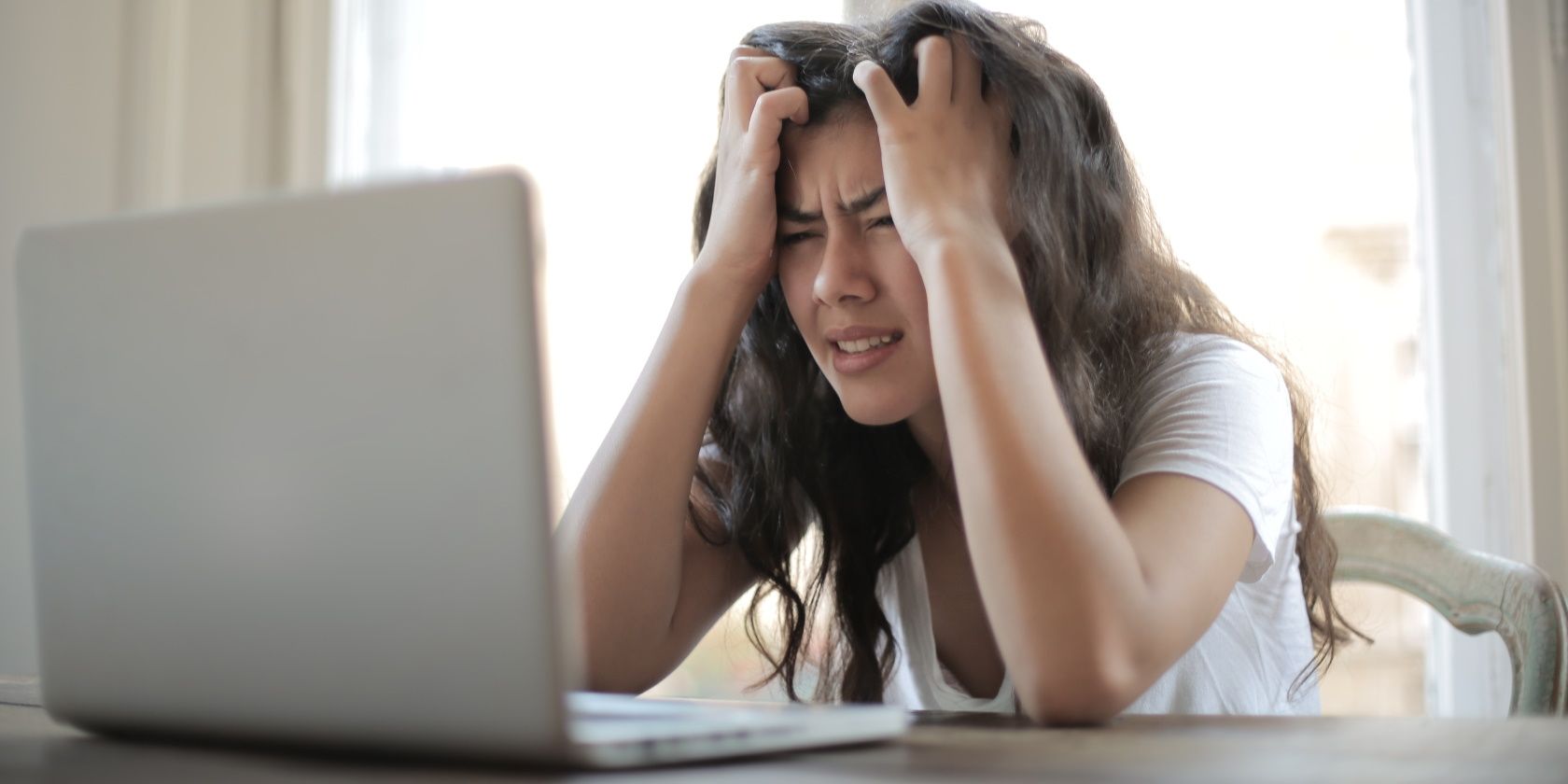 Uma mulher parecendo estressada na frente do computador