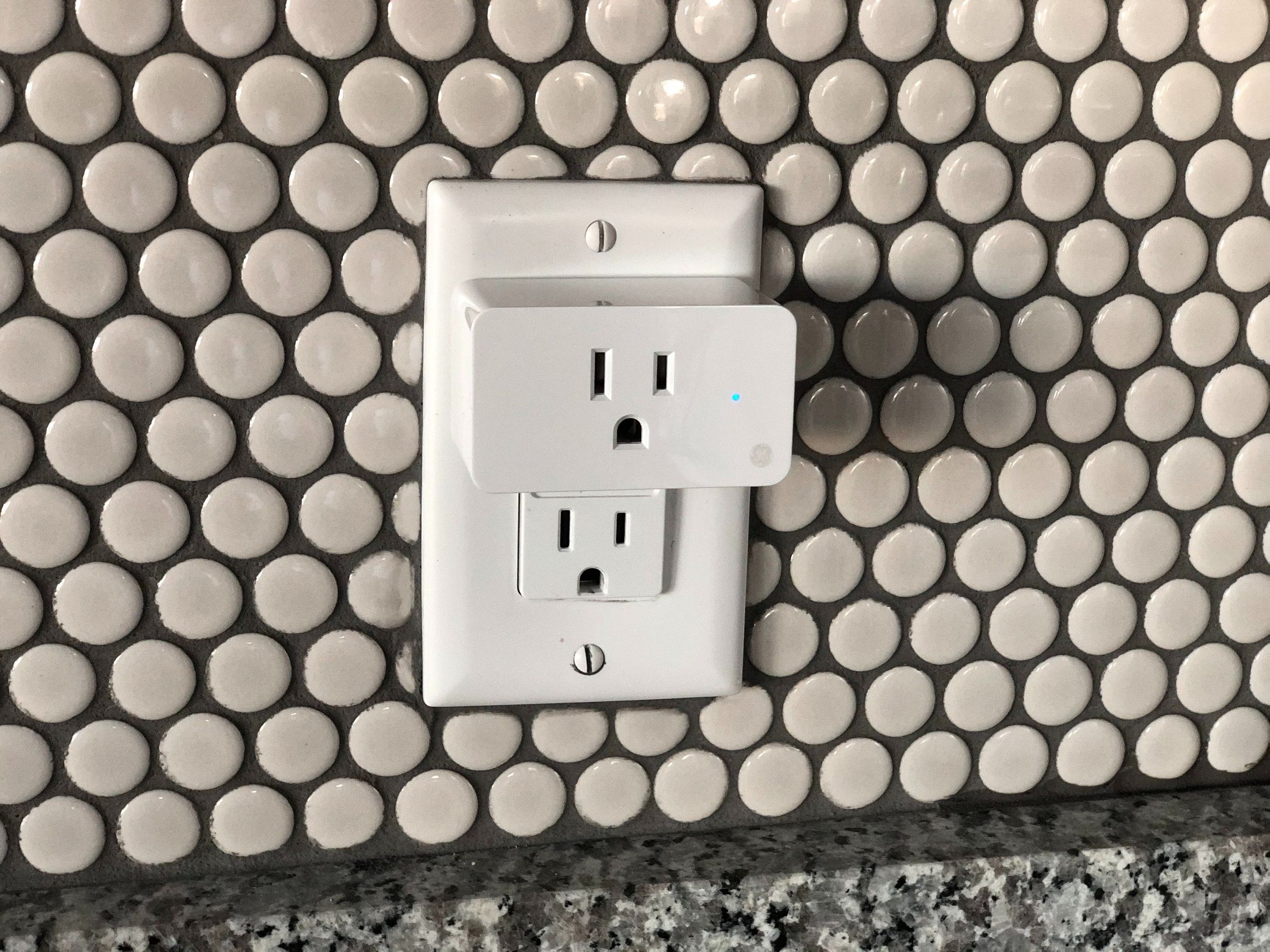 A smart plug plugged into a kitchen socket.
