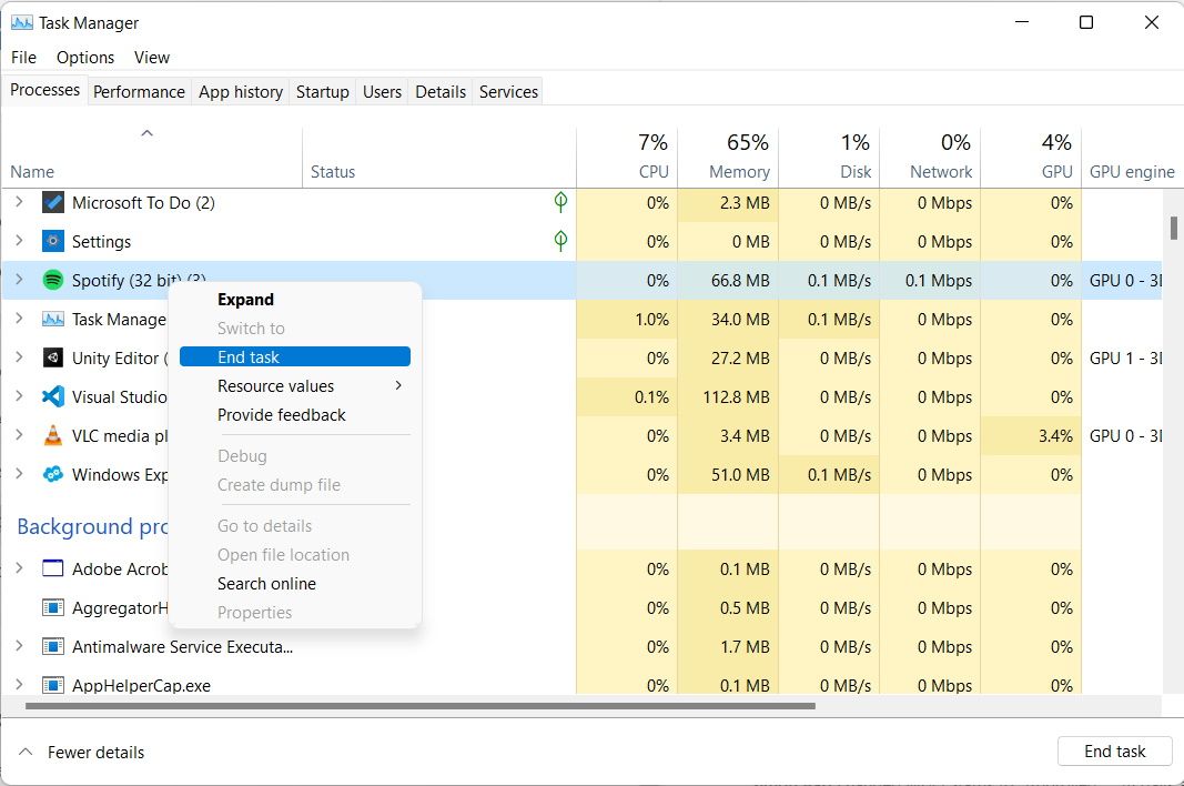 Task Manager's 'Processes' tab, with Spotify right-clicked and the 'End Task' option highlighted.