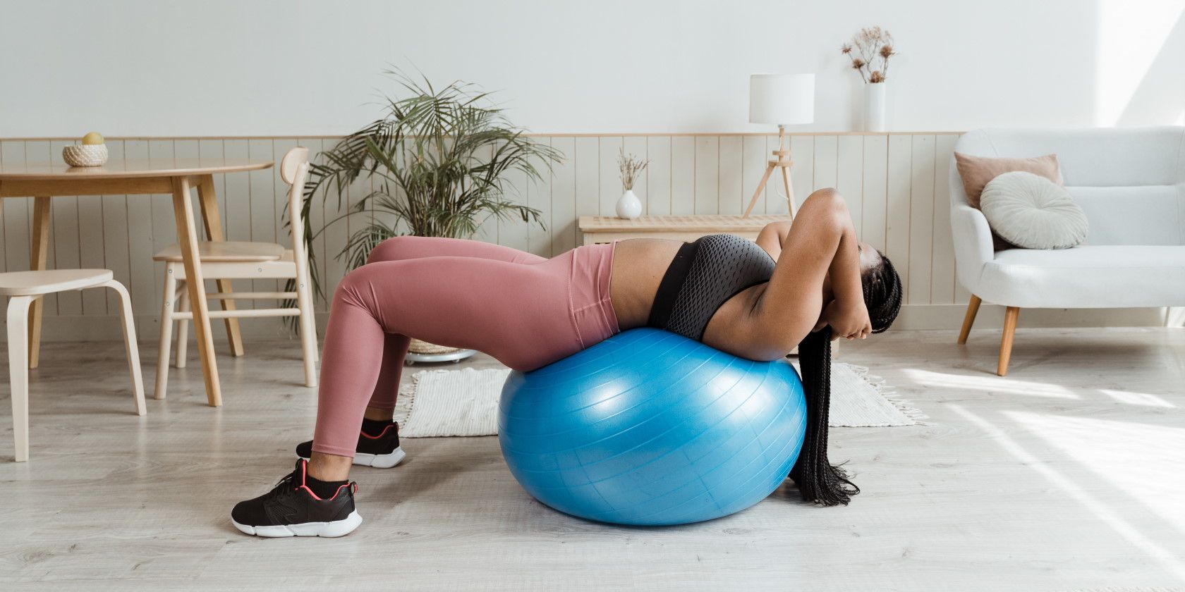 Woman using exercise ball to workout at home