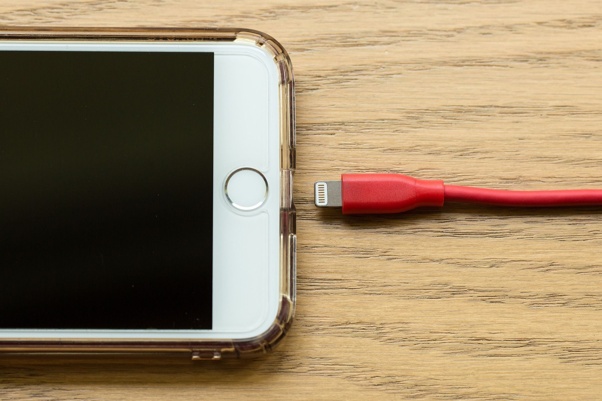An iphone with a charging cable ready to plug in
