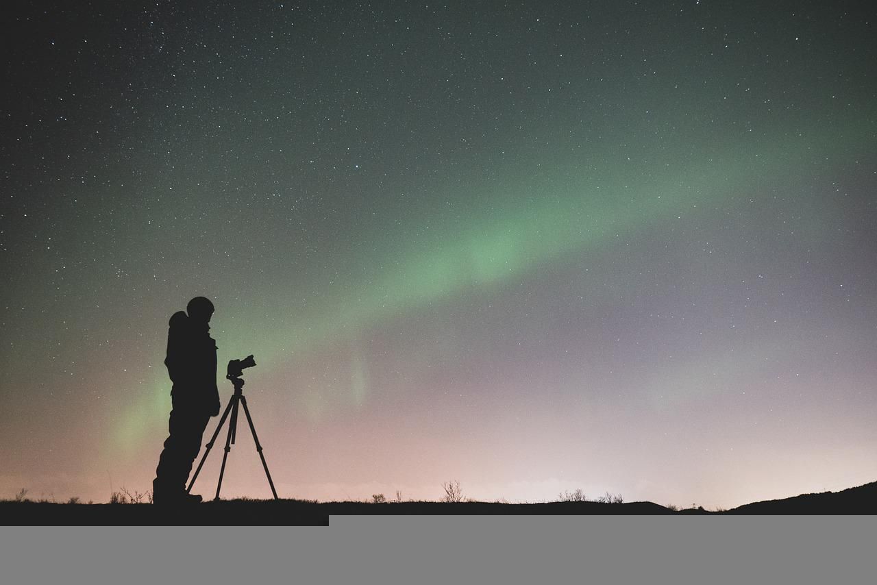 Photographer looking over Aurora Borealis