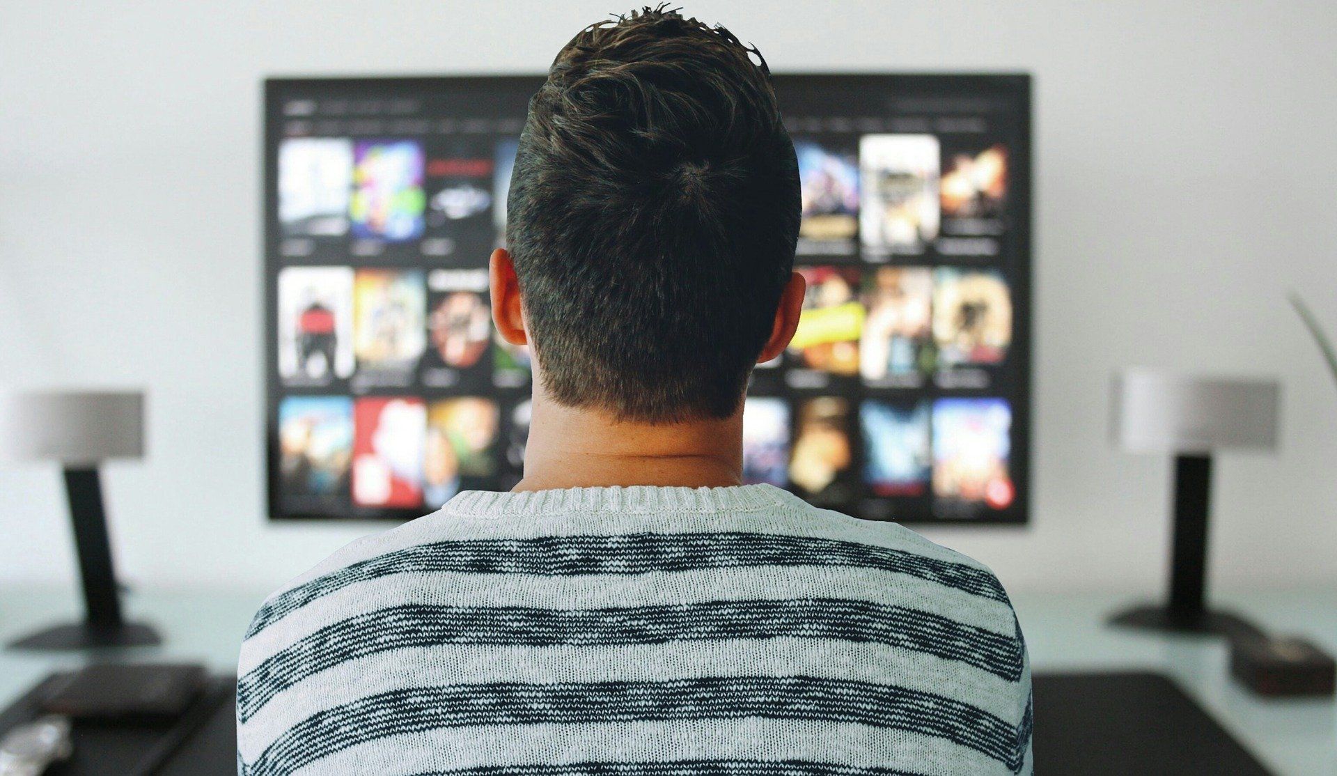Man in striped shirt watching TV