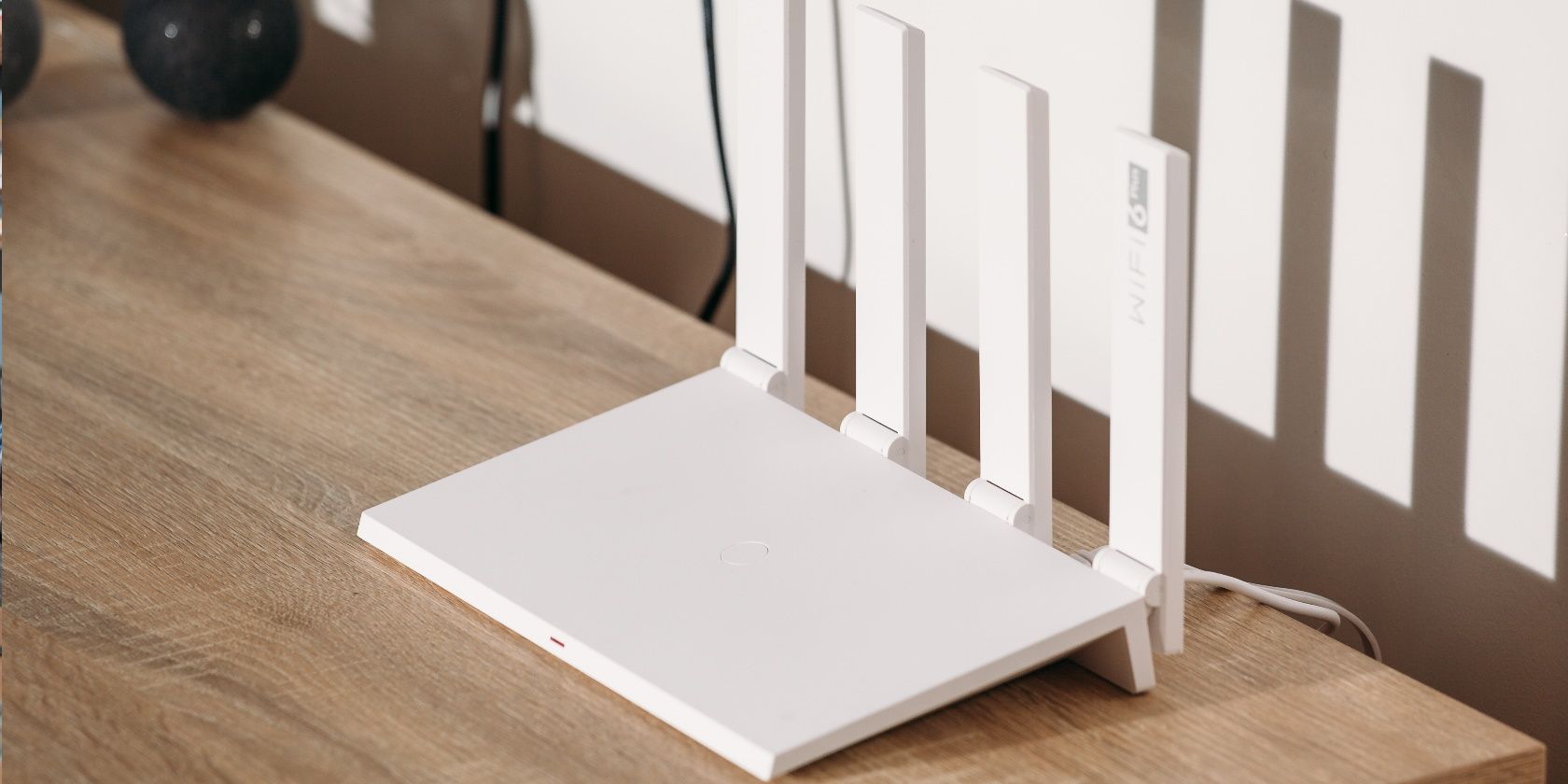 White Wi-Fi 6 router with 4 antennas on a wooden table