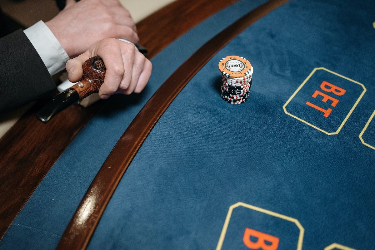 a man holding a pipe near gaming table