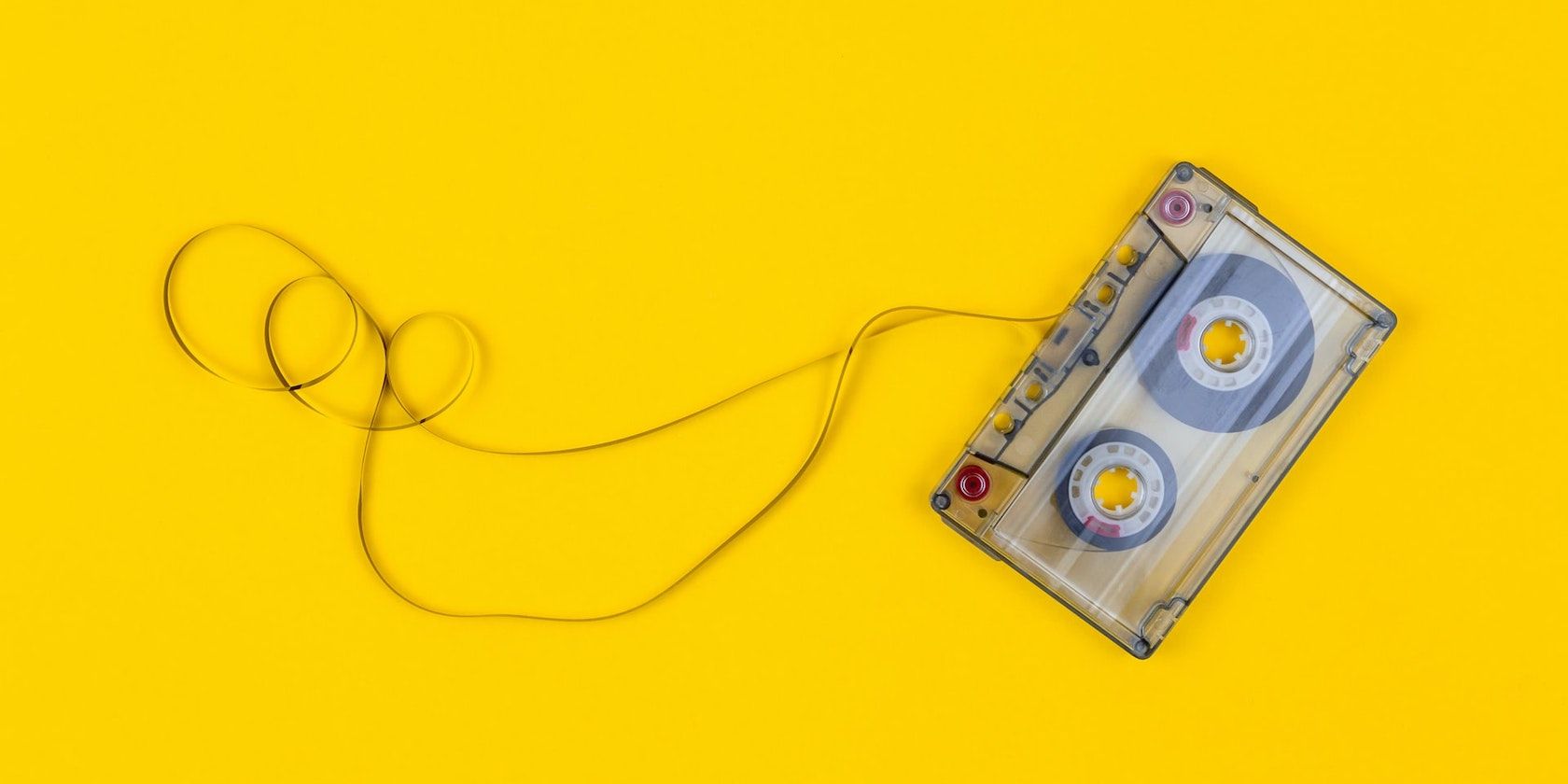 A photo of a cassete tape on a yellow background.