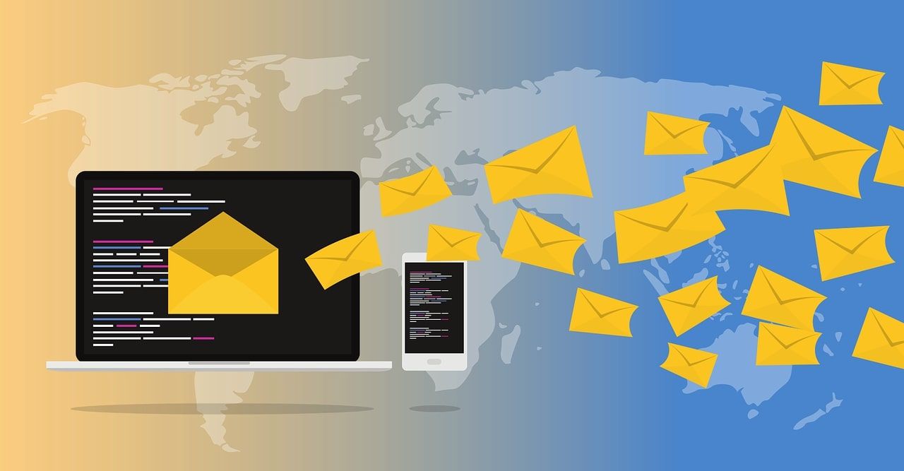 پاکت های ایمیل از لپ تاپ در مقابل نقشه جهان