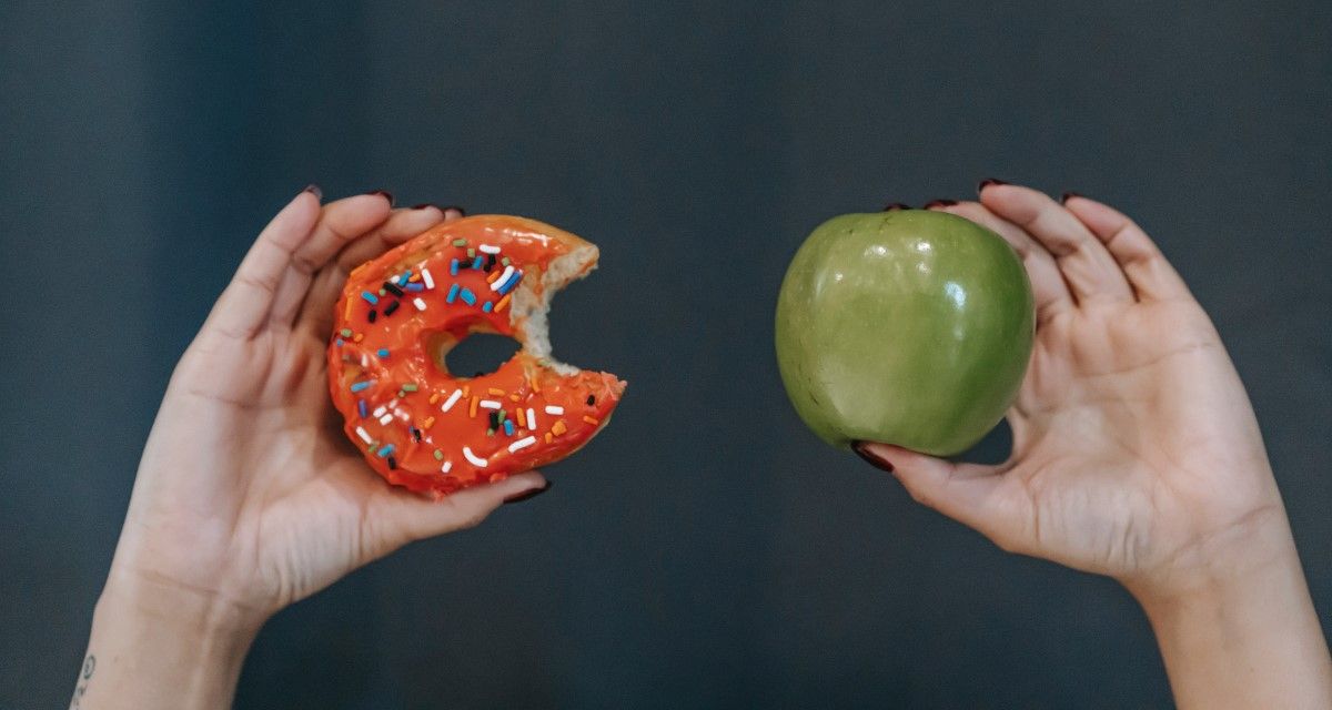 hands-holding-donut-and-apple