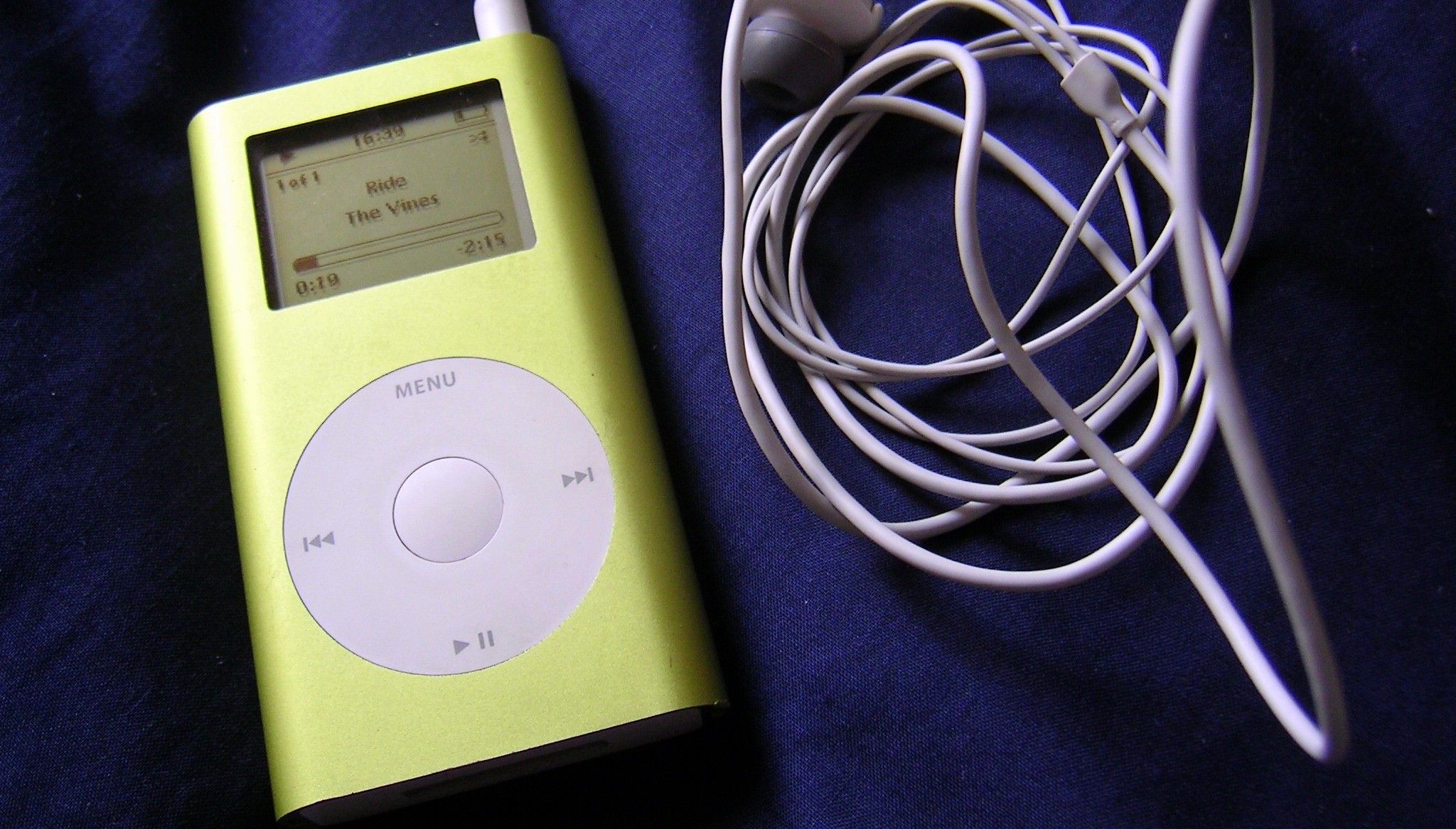 iPod Mini with headphones lies on fabric surface