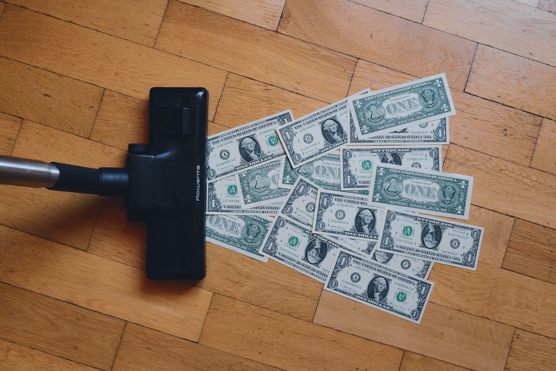 Image of a vacuum cleaner sucking up cash