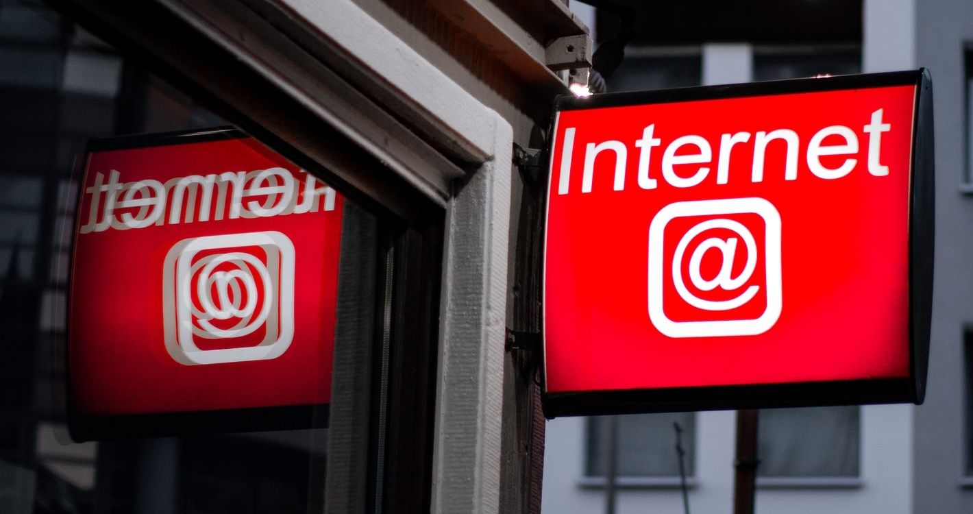 Red internet sign with reflection in window pane.