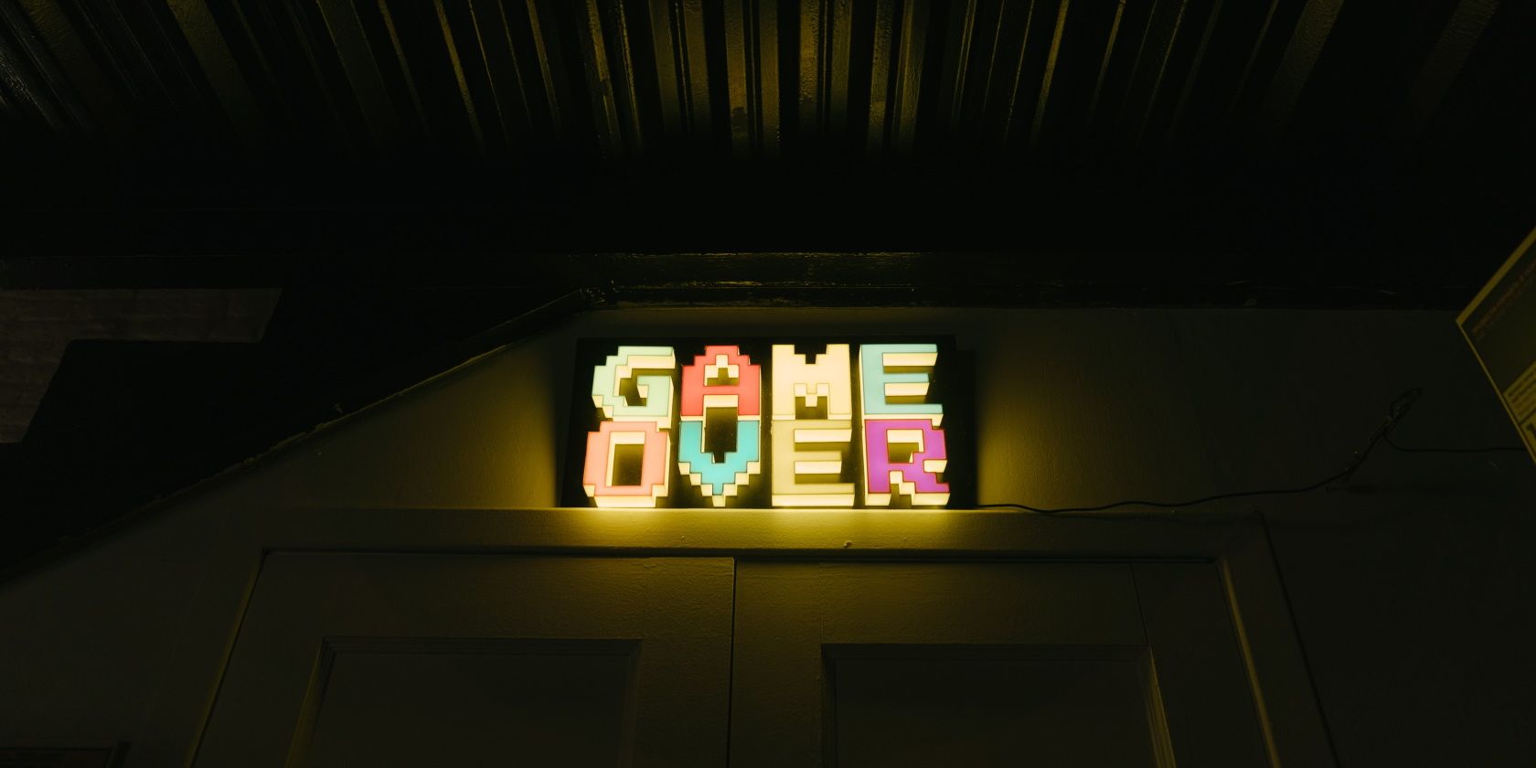 a multicolored game over sign over a doorway