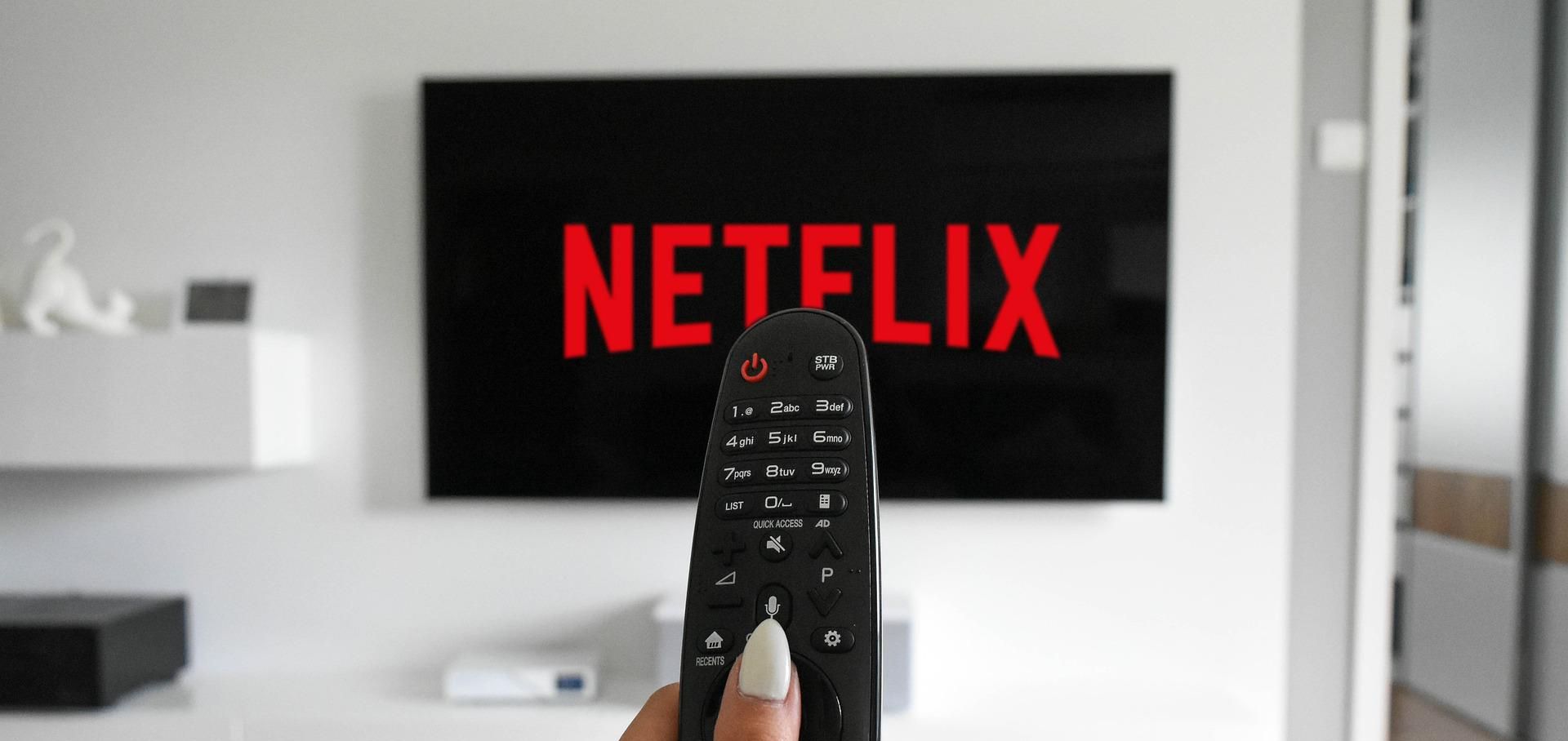 person using remote to put netflix on television
