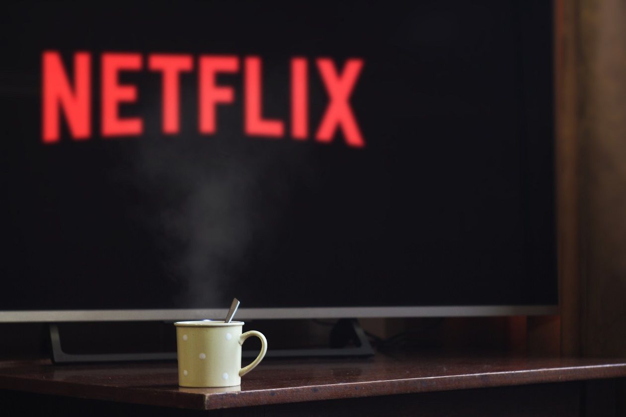 cup on table infront of flatscreen tv with netflix logo