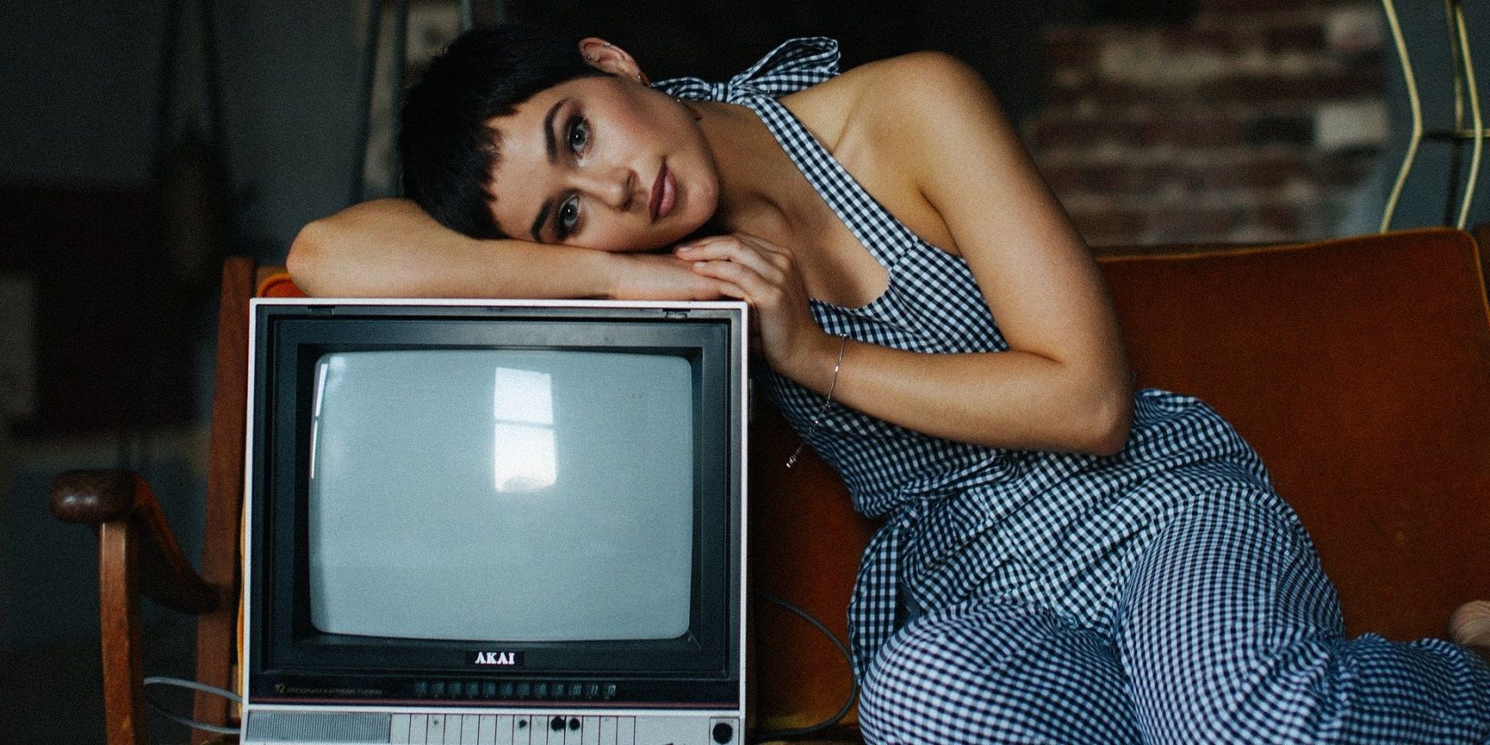 photo of lady leaning on old tv