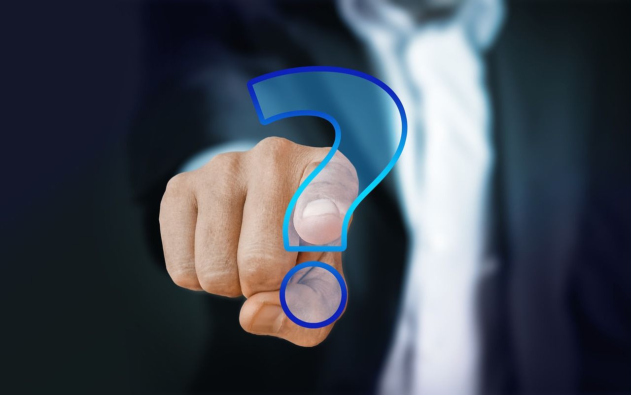 man pointing towards a question mark