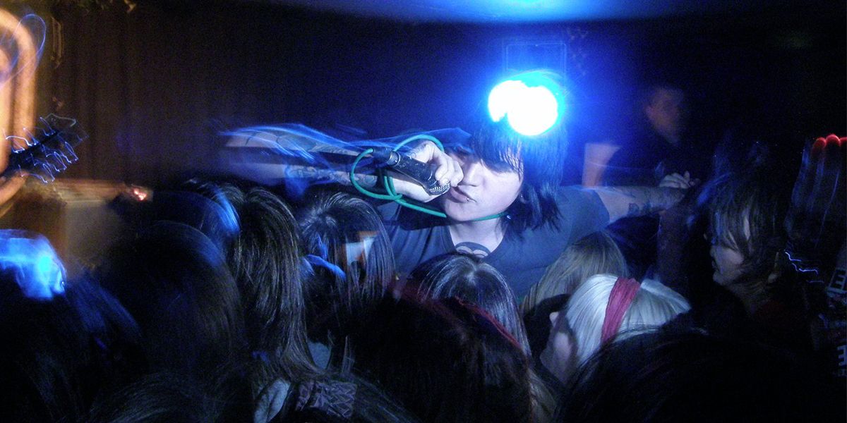Lead singer of band leaning into crowd.