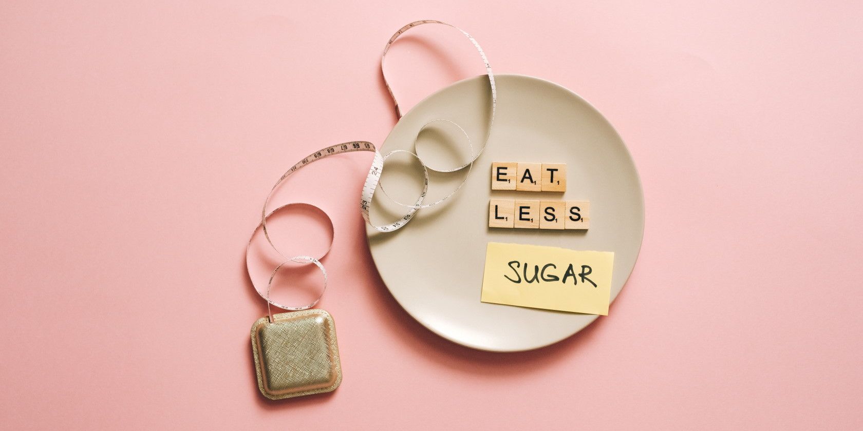 Dinner plate with letters spelling eat less sugar next to measuring tape