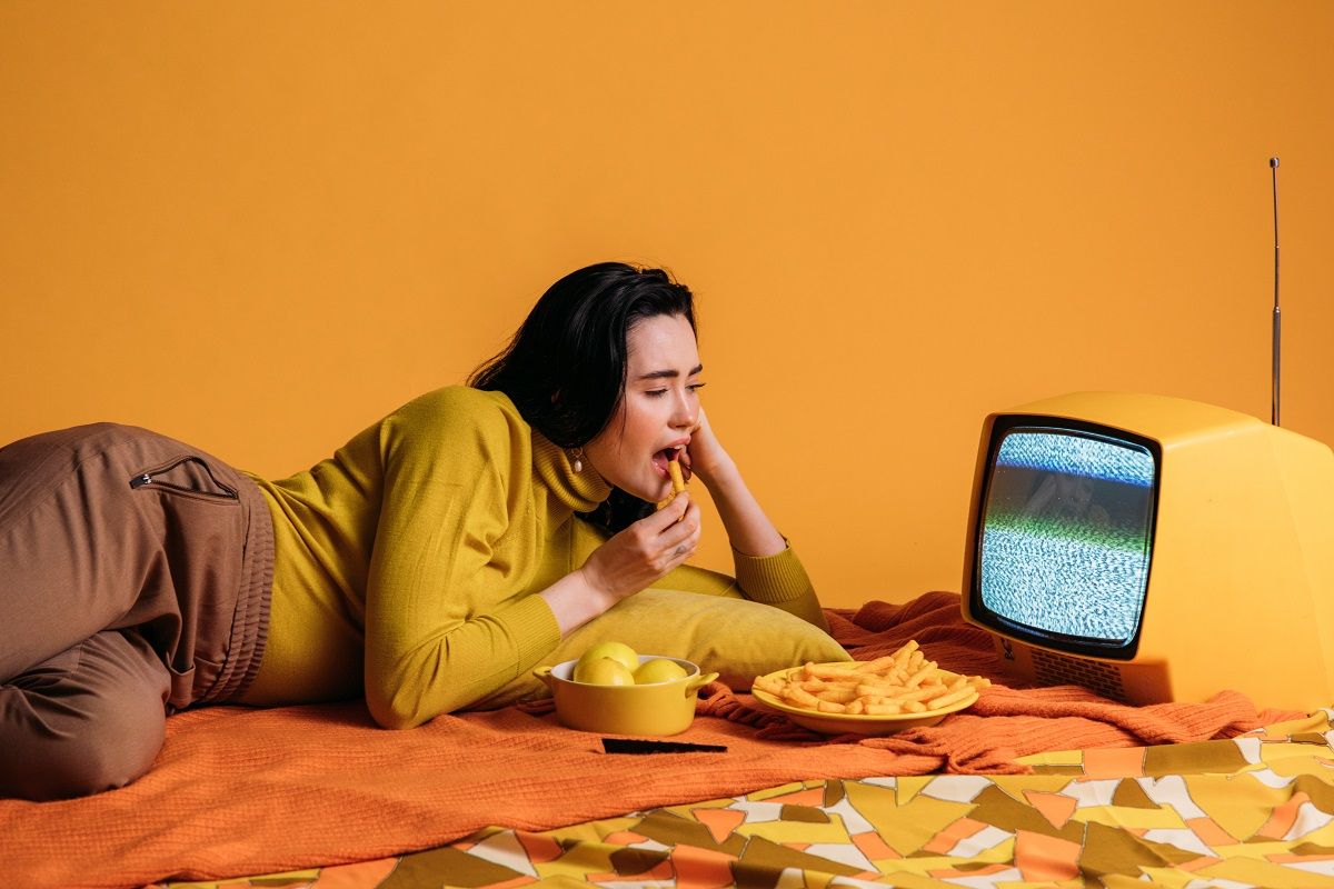 woman on bed watching tv