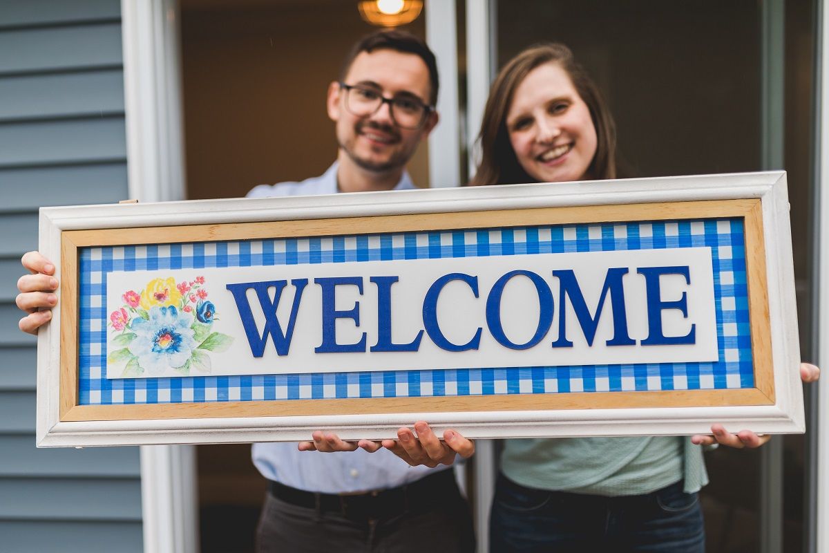 man and woman holding welcome sign