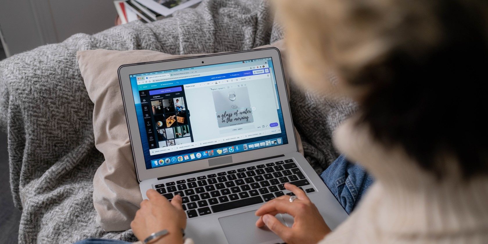 woman in sweater using Canva on laptop