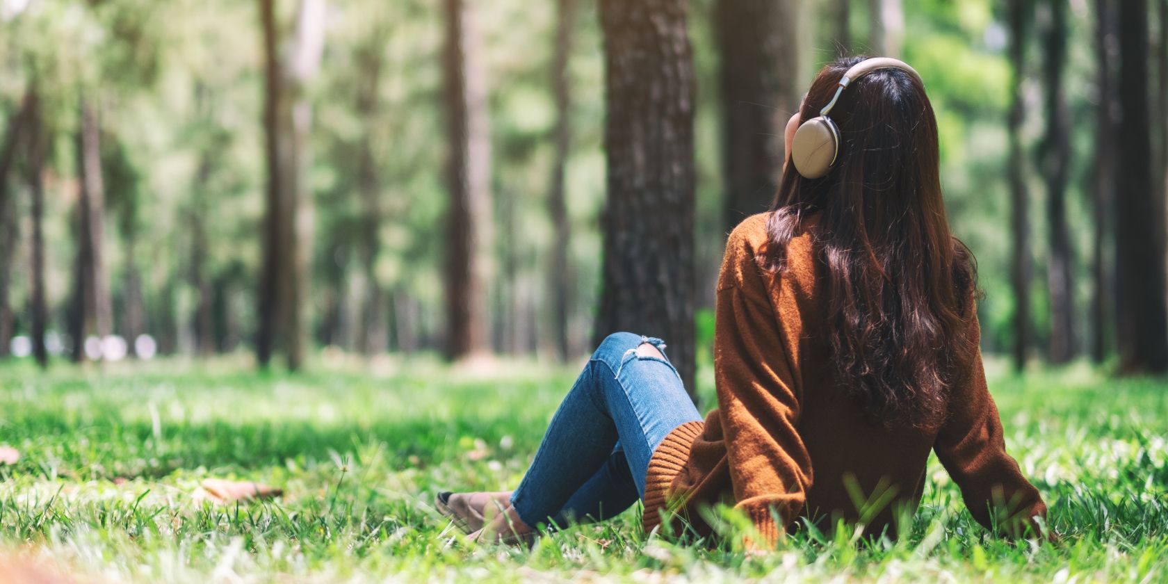 woman wearing headphones relaxing in forest