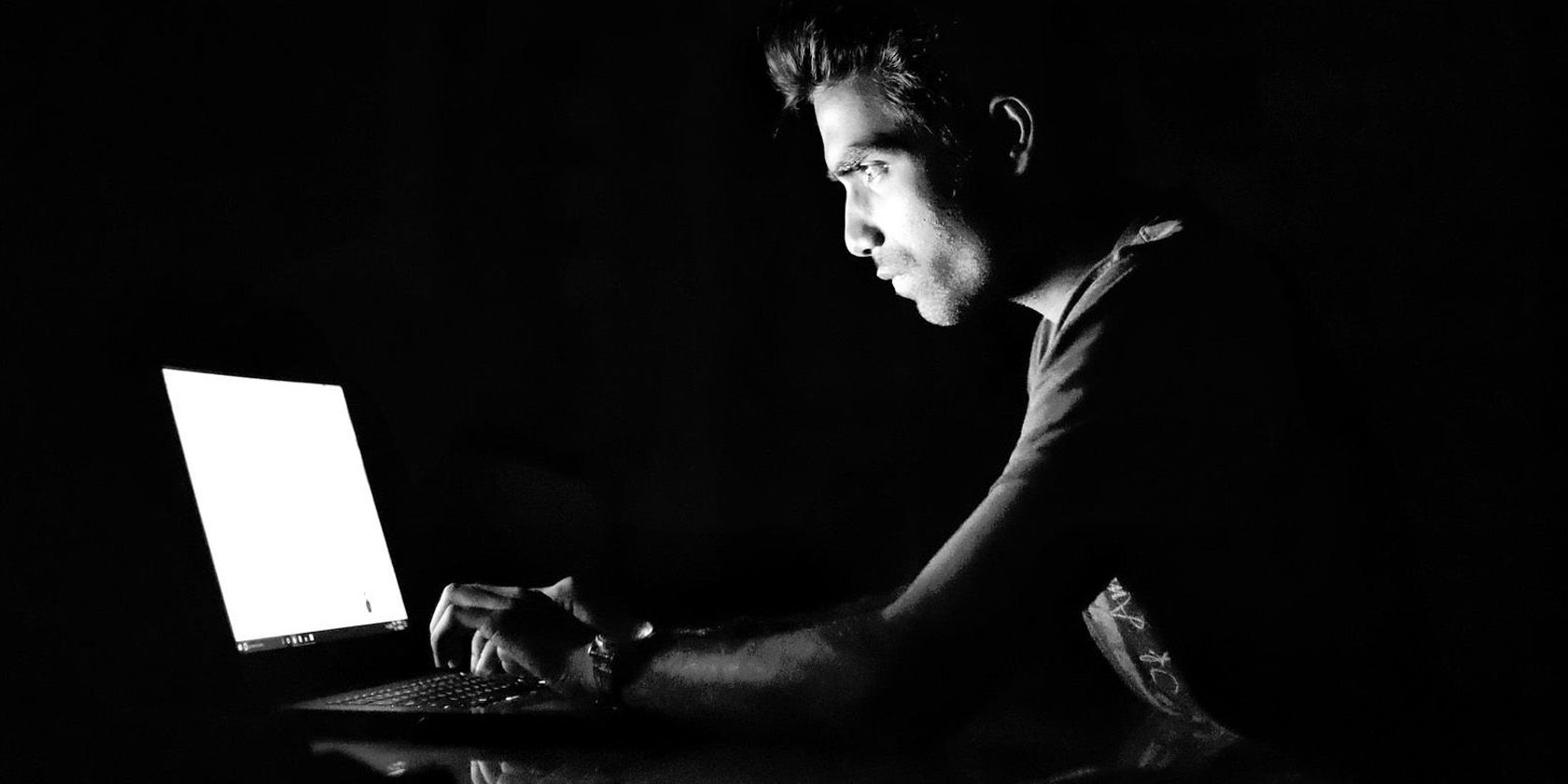 Man in the dark using laptop