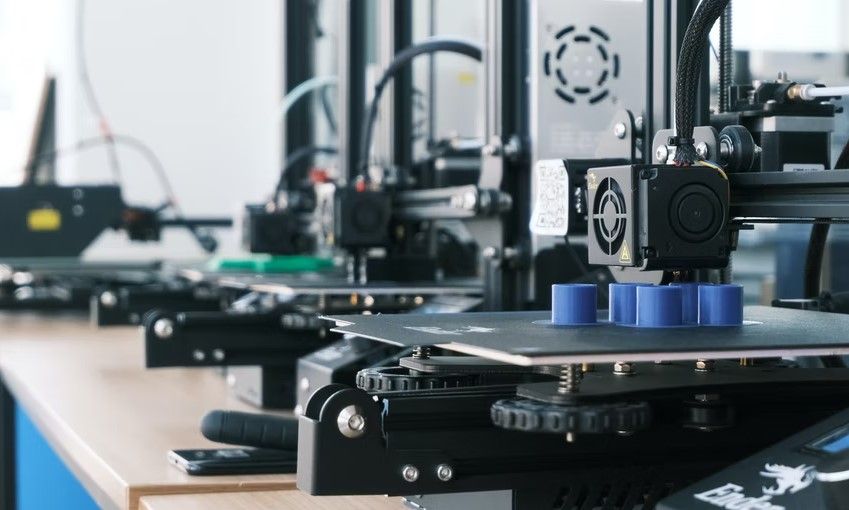 Several 3D printers displayed on a table printing objects
