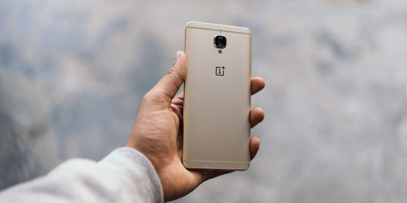 Person holding a gold OnePlus 3 in their hand