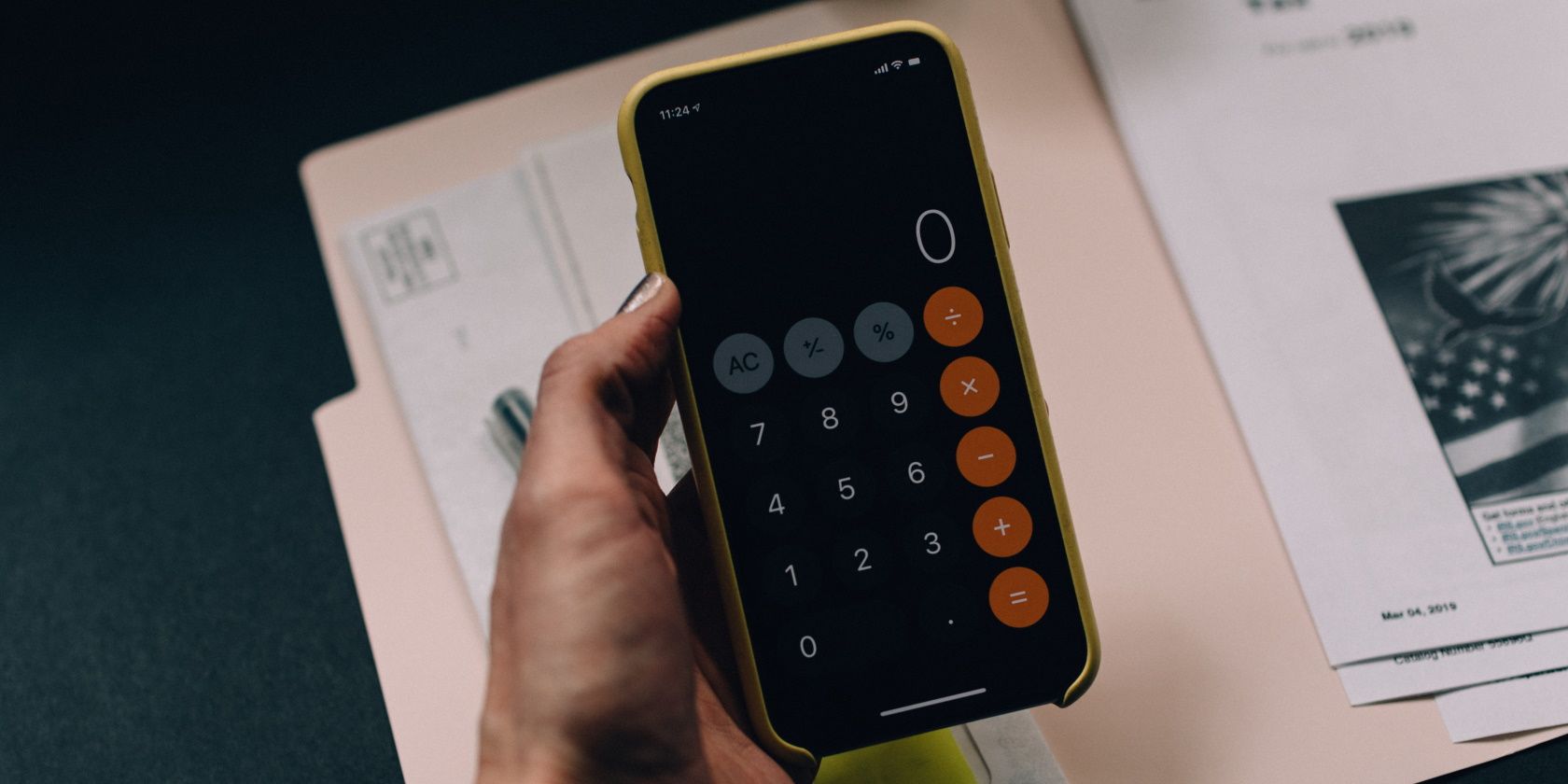 Person holding iPhone with Calculator App opened