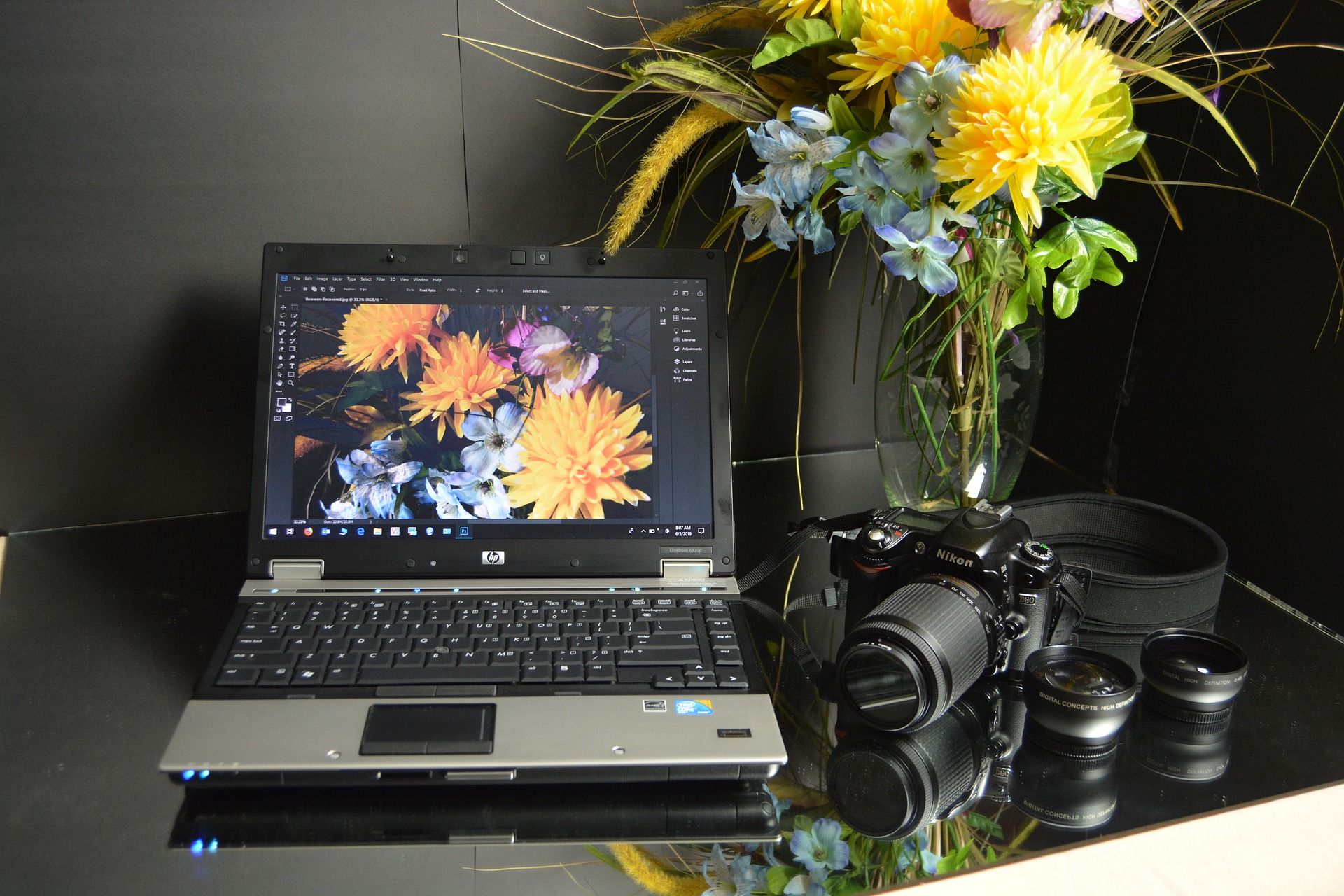 Laptop showing photo editing software and camera