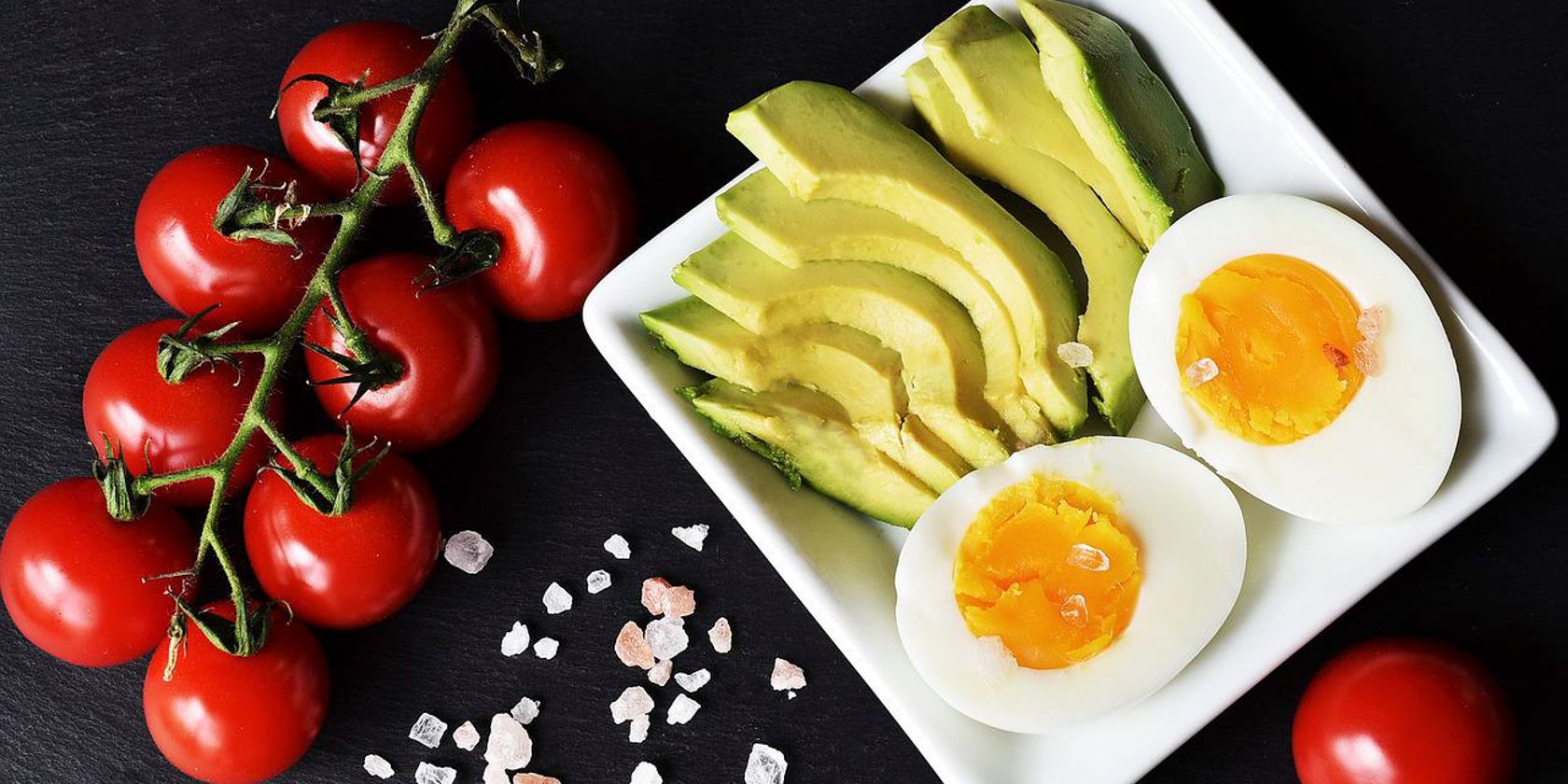 Photo showing a plate of keto friendly food including tomatoes eggs and avocado