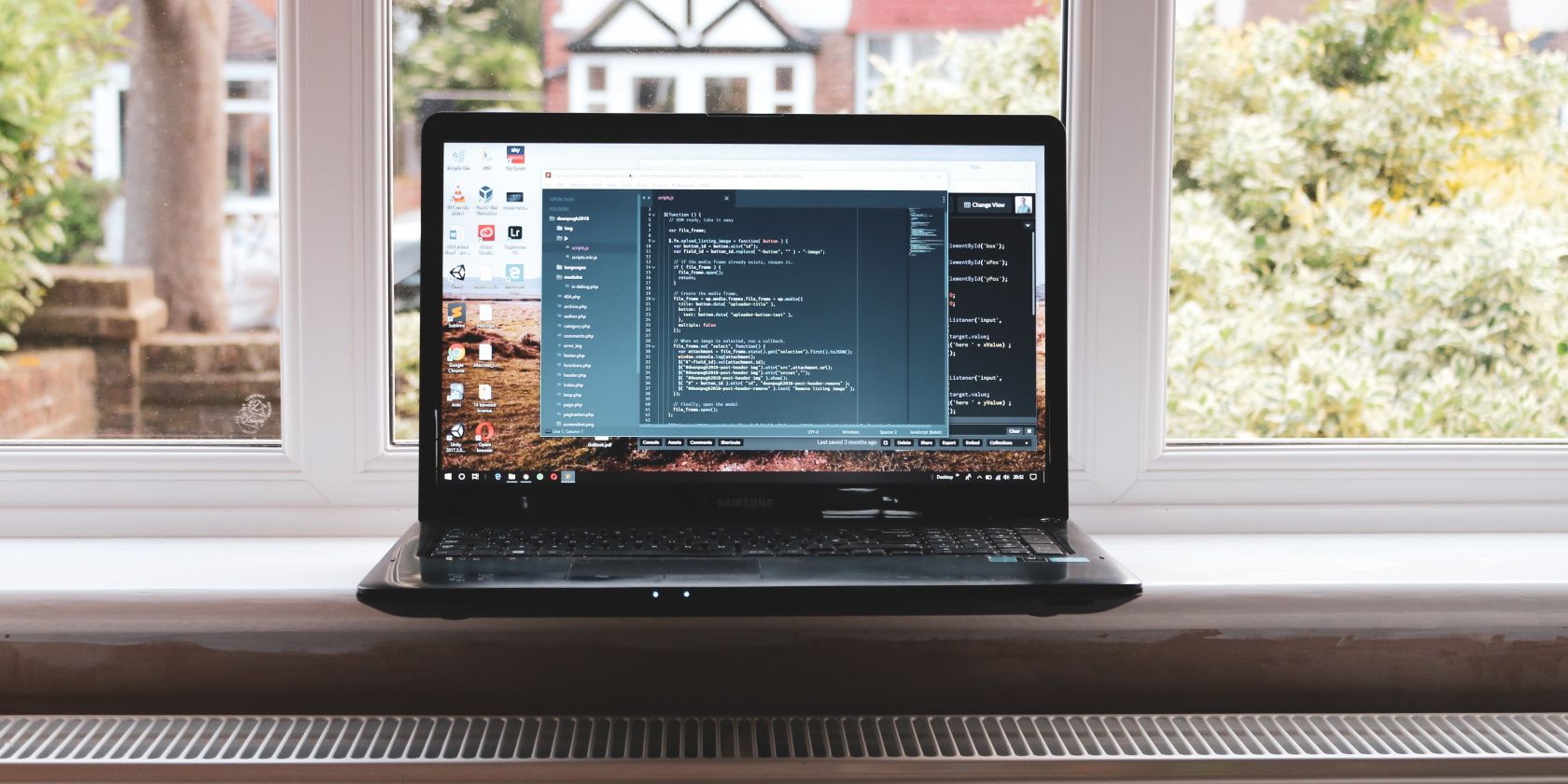 A laptop computer sitting in front of a window with code on the screen
