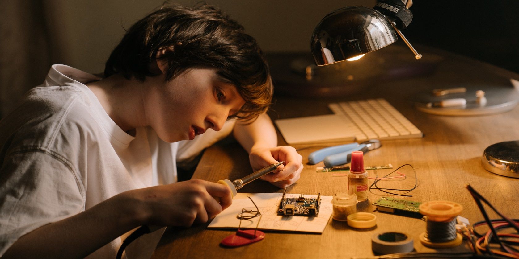 A girl in white short sleeve shirt soldering