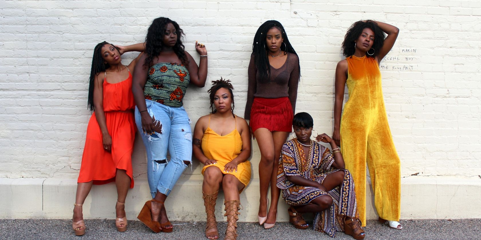 black women against white wall in colorful clothing